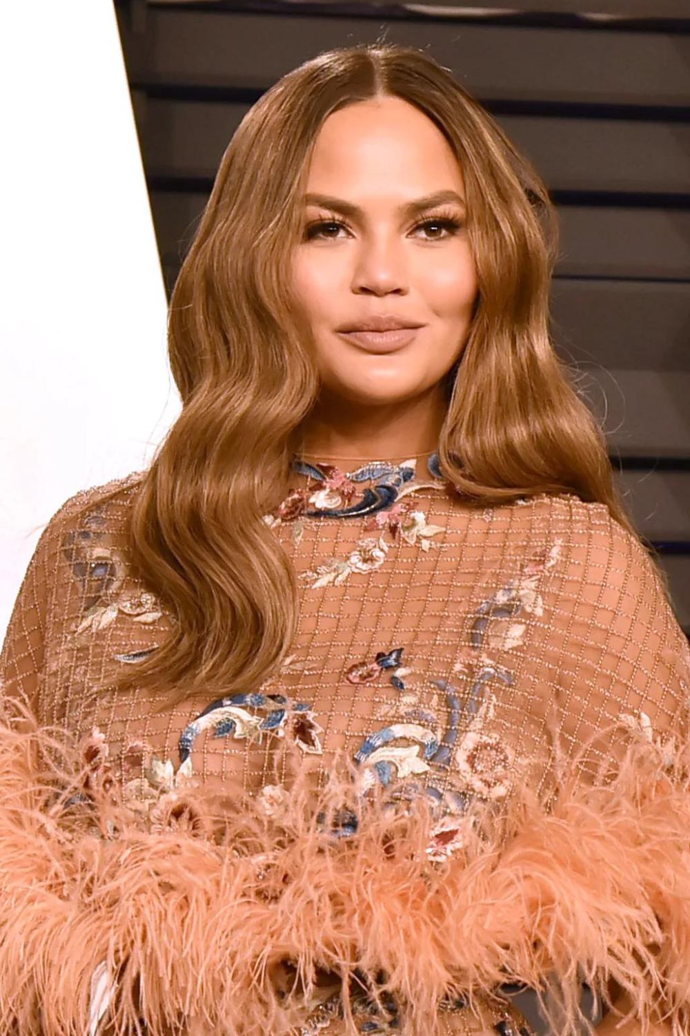 Chrissy Teigen's long layers and centre part help create balance. Photo / Supplied