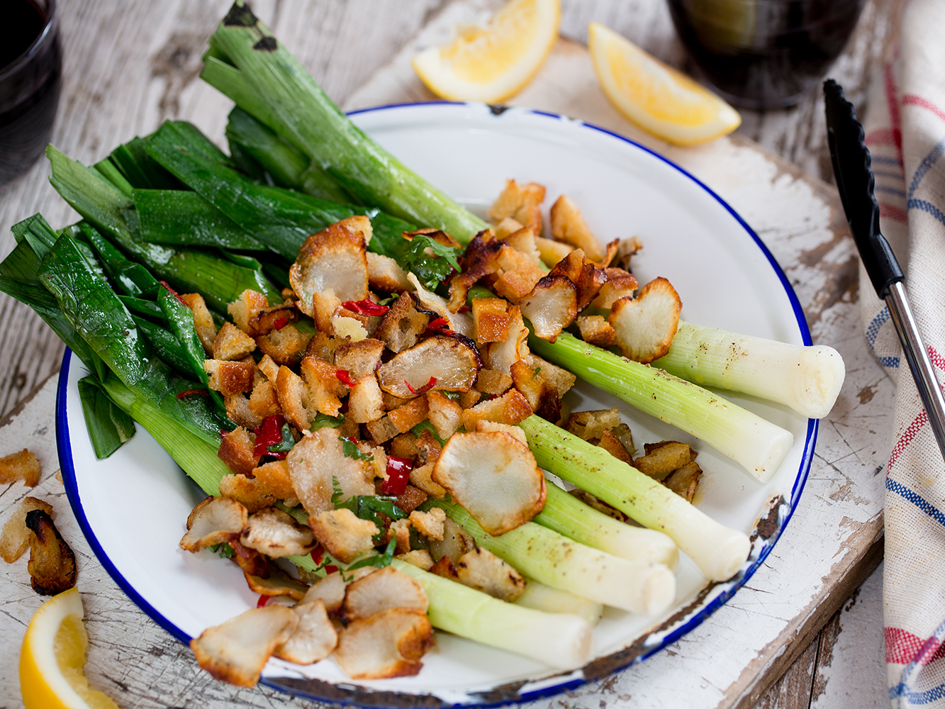 Serve the hot leeks on a platter scattered with the crumb and artichoke crisps. Picture / Babiche Martens