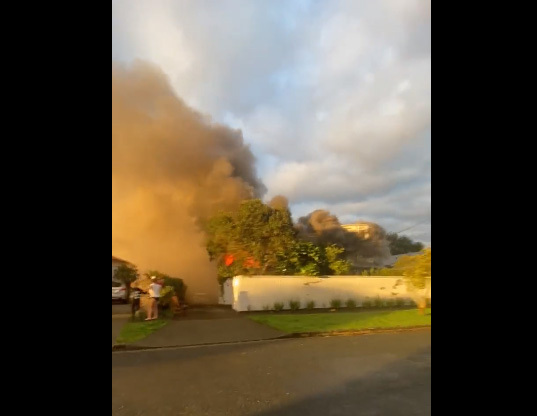 Dark smoke and shooting flames are visible from a burning house that caught fire in Western Springs Rd on Sunday morning. Photo / Supplied