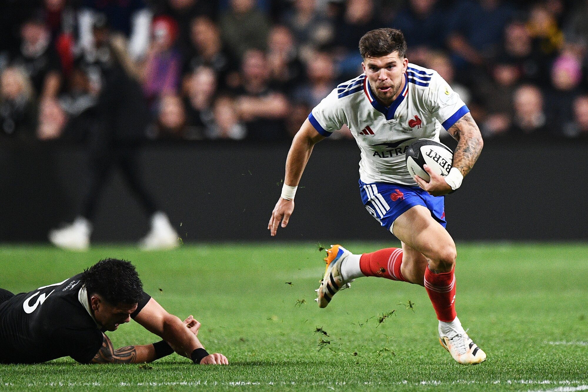 Frenchman Matthieu Jalibert skips away from an All Blacks tackle in the test match in Christchurch. Photo Photosport