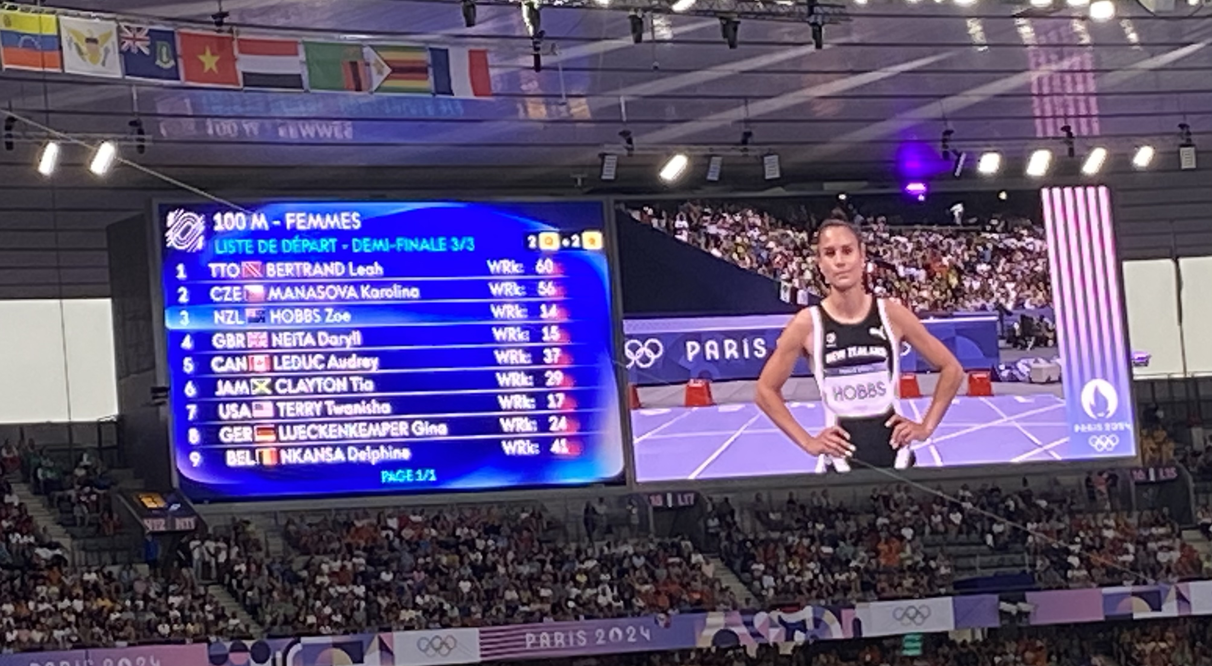 Kiwi Zoe Hobbs on the giant screen ahead of her 100m semifinal at the Paris Olympics