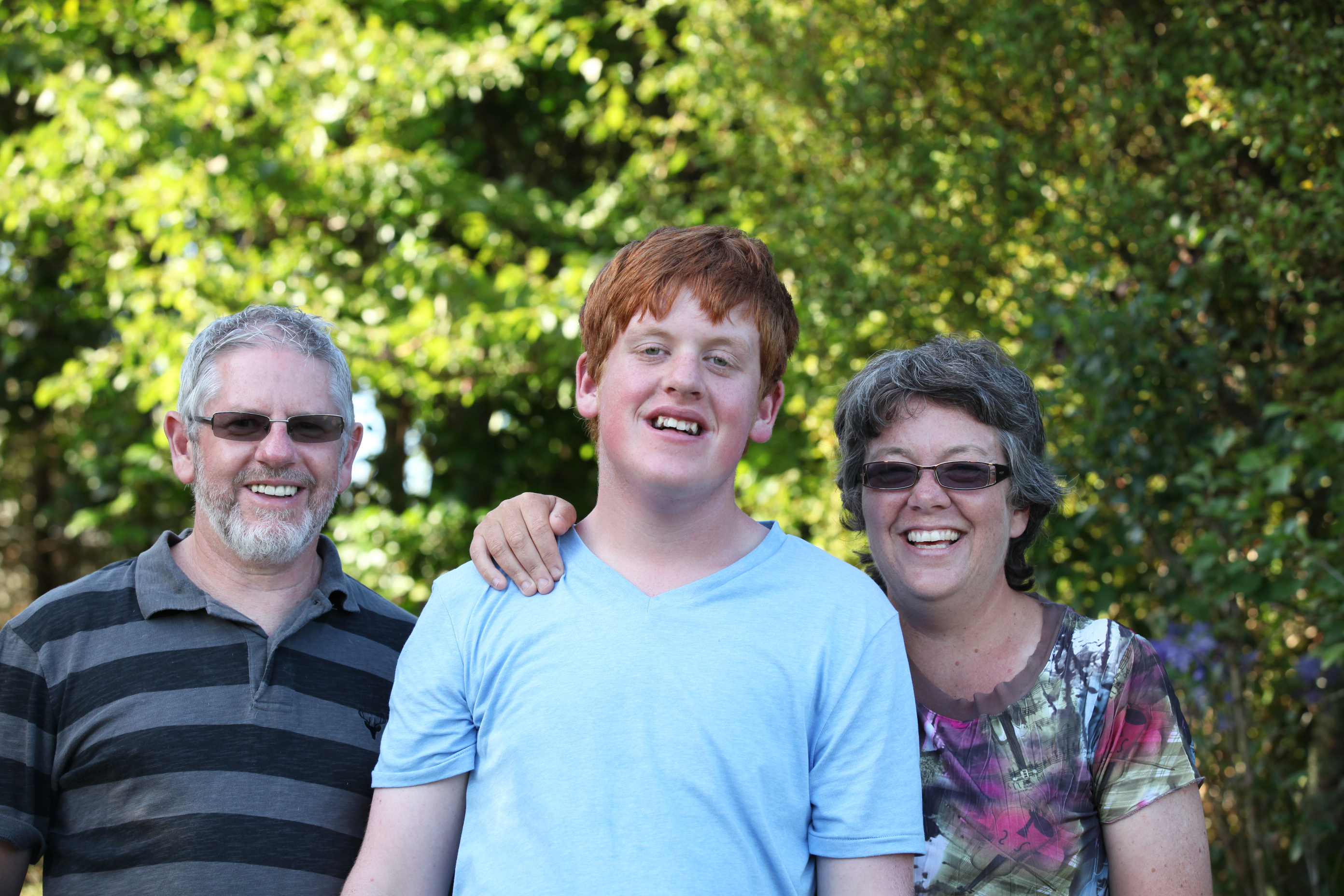 James Hollis (middle) is intellectually disabled and lives with his parents, Chris Hollis and Anita Nicholls. They are concerned about a funding freeze for disabled people who need residential care.