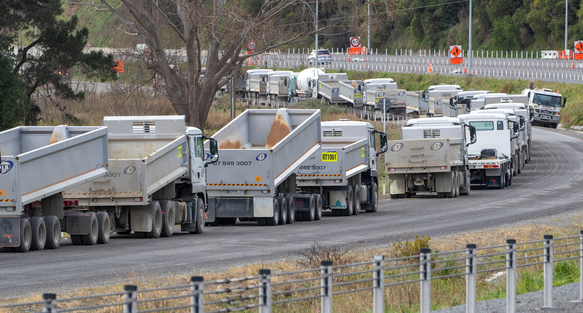 Truck and trailer units parked alongside a section of the Transmission Gully project during lockdown. Photo / Mark Mitchell 