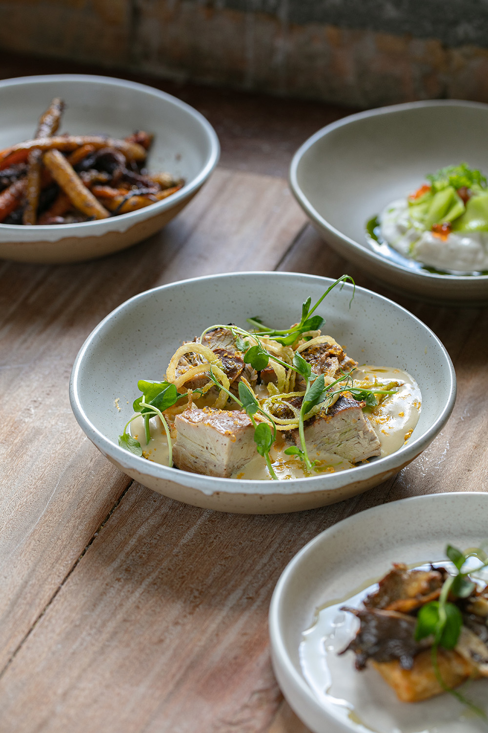 The hāngī pork belly with potato mousse, crispy onions, cured egg yolk and chive oil at Ada. Photo / Babiche Martens