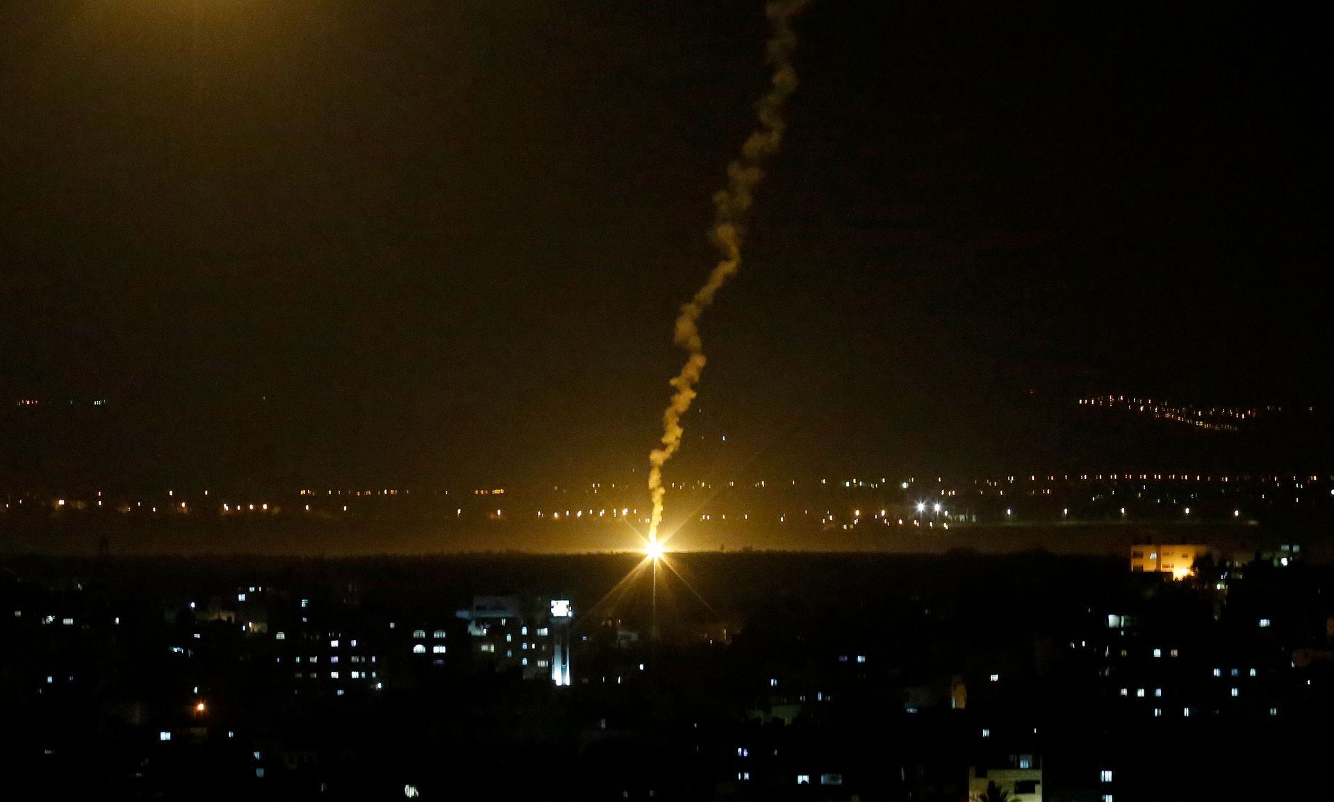 Flares fired from Israeli forces light up the night sky in Gaza City.