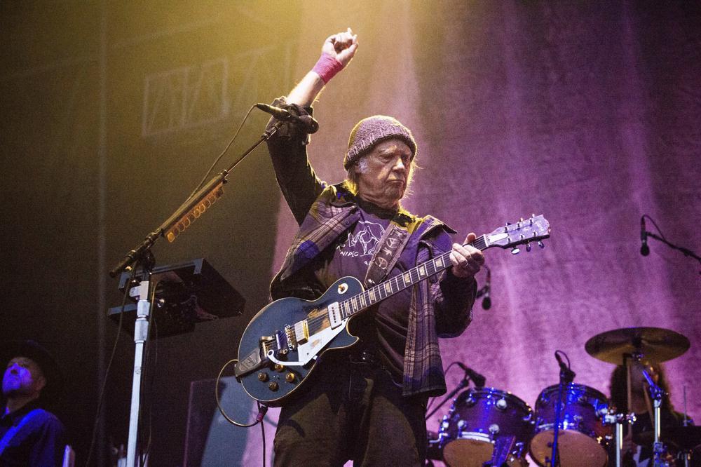 Following protests of Spotify started by Neil Young the music streaming service will add content advisories before podcasts discussing the virus. Photo / AP