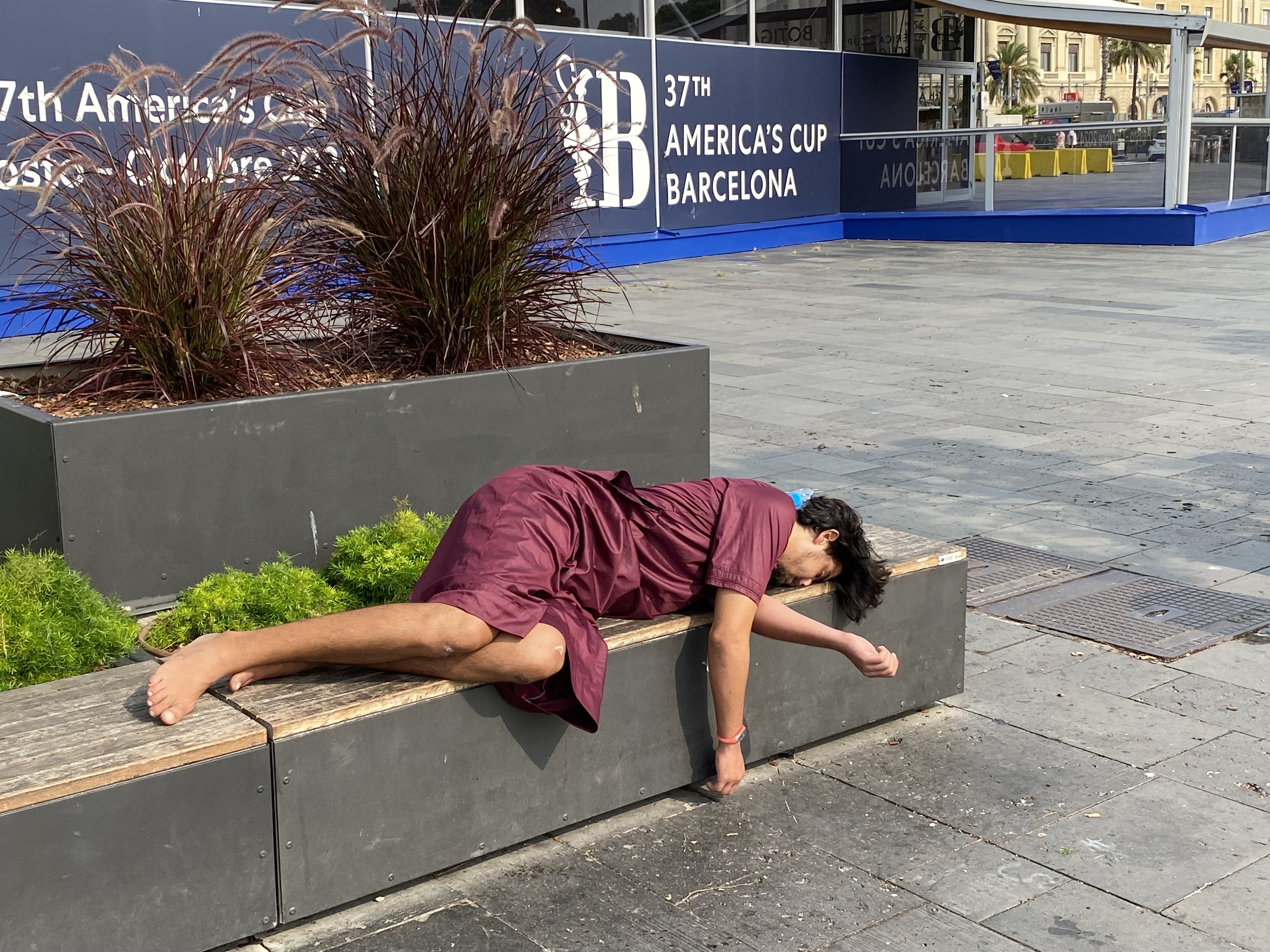 A partygoer recovering after a big night, outside the official America's Cup store in Barcelona. Photo / Michael Burgess