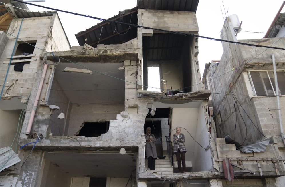 Mourners watch the funeral processions of killed Palestinians from their partly destroyed house in the West Bank refugee camp of Tulkarem. Photo / AP