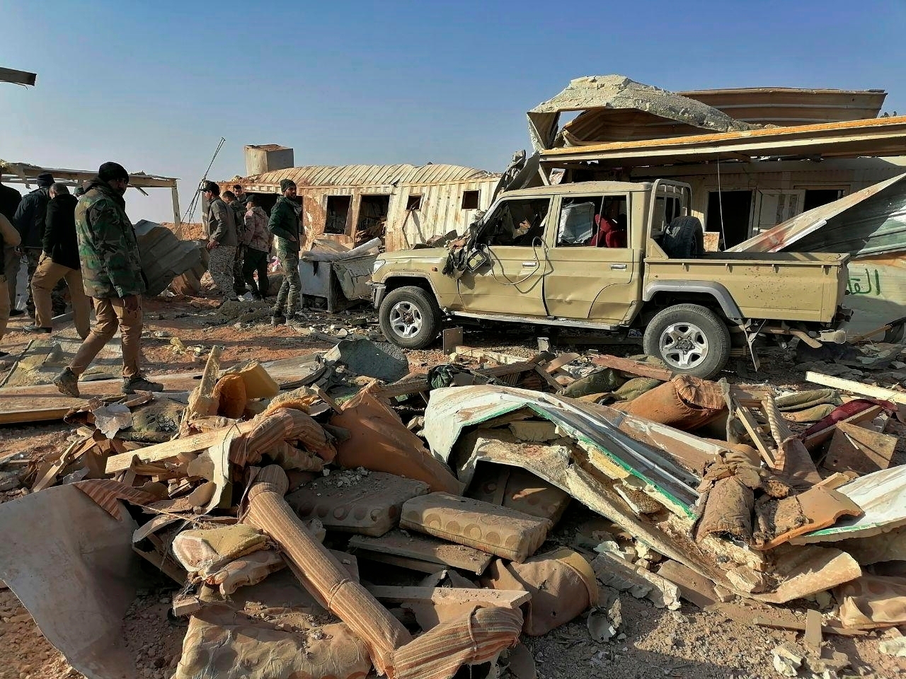 Fighters from the Kataeb Hezbollah, or Hezbollah Brigades militia, inspect the destruction at their headquarters in the aftermath of a US airstrike in Qaim, Iraq. Photo / AP
