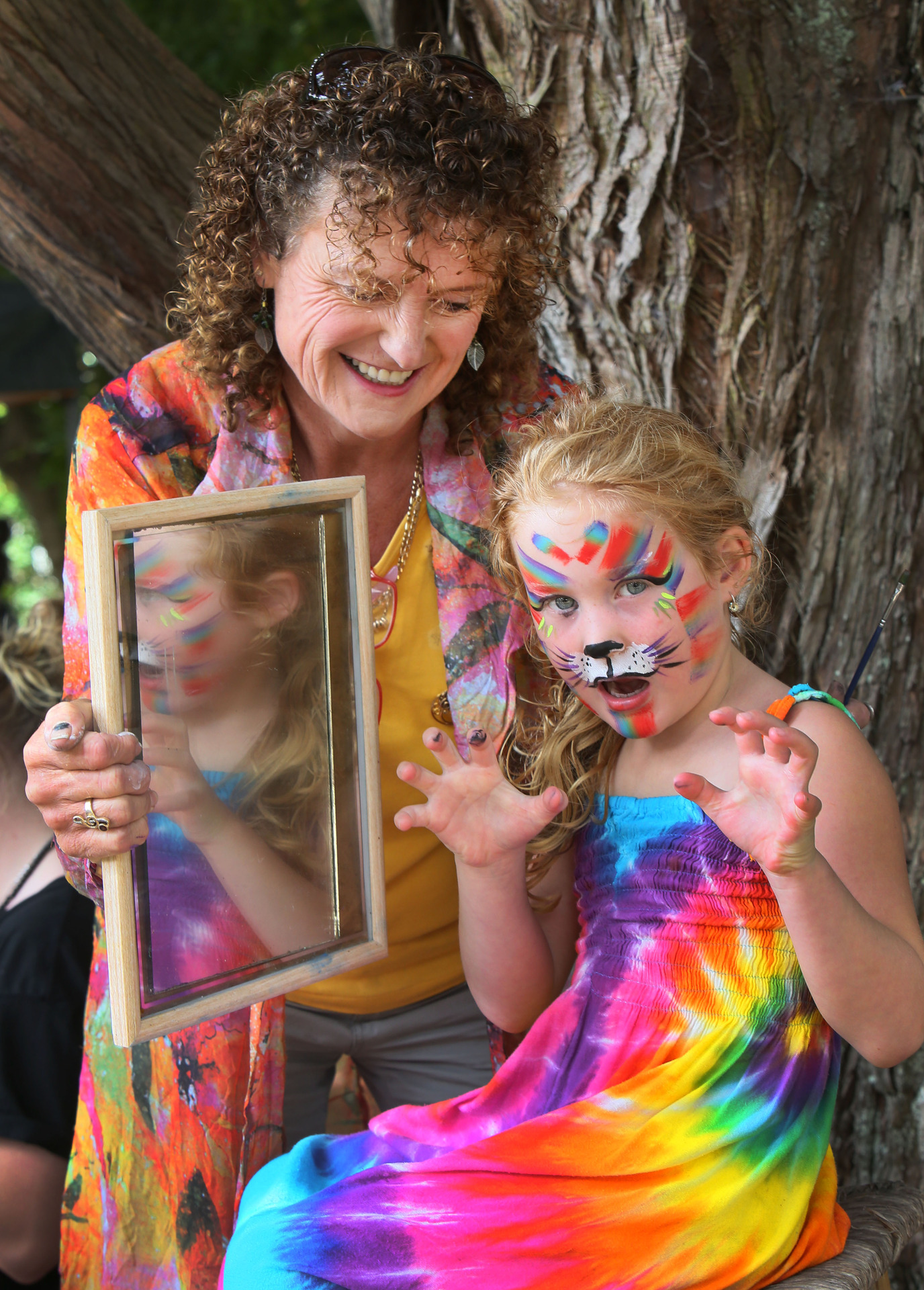 Debbie Walters-Brown holds the looking glass to show Hazel MacDonald her cat-like painted face
