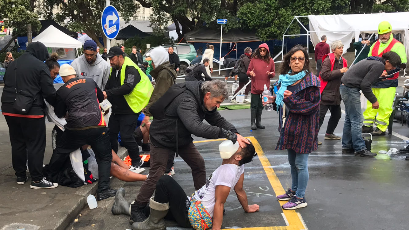 People at the original convoy occupation tend to injured fellow protesters on Molesworth St outside Parliament on March 2, 2022. Photo / John Weekes