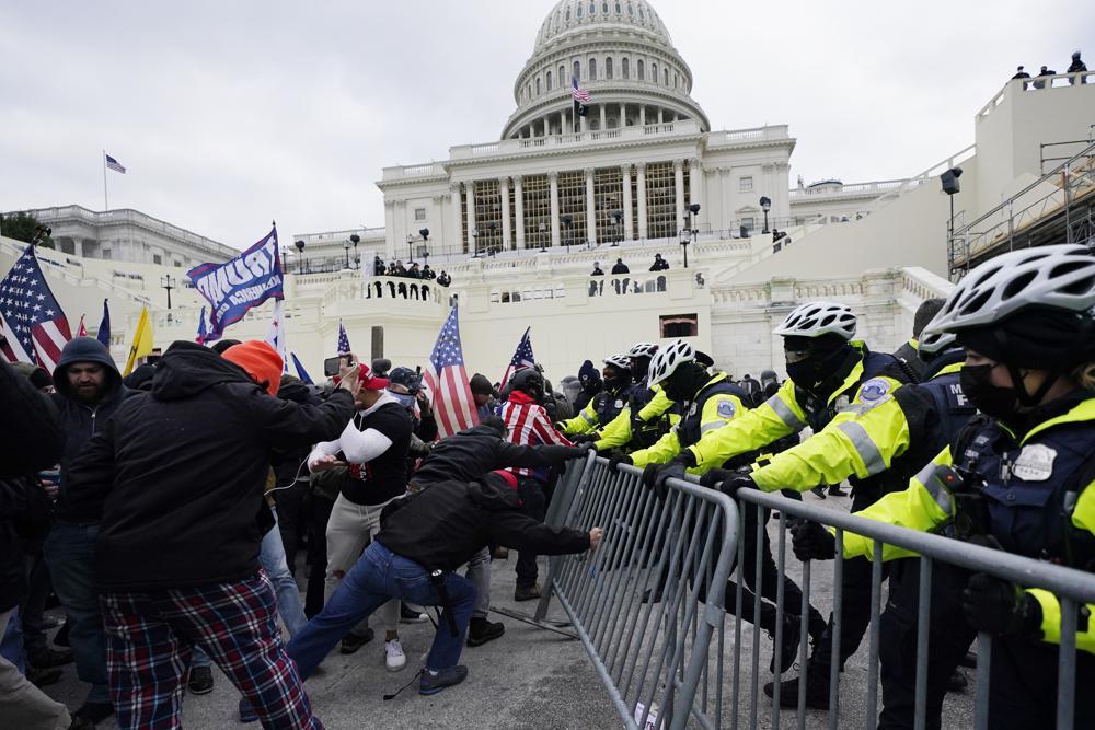 Insurrectionists loyal to President Donald Trump try to break through a police barrier on January 6 last year. Photo / AP