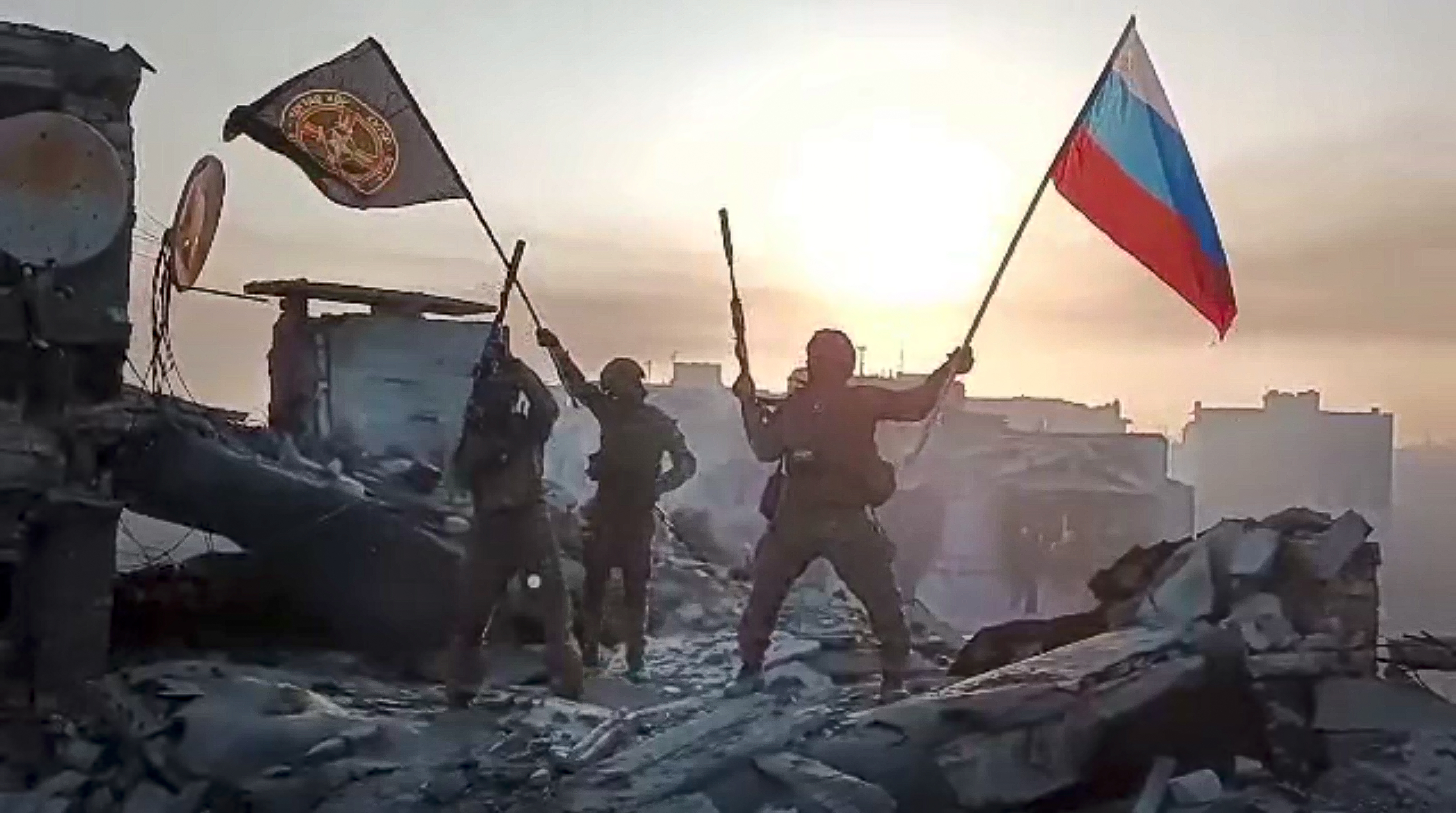 Wagner private military forces wave Russian and Wagner flags atop a damaged building in Bakhmut, Ukraine. Photo / Prigozhin Press Service via AP, File