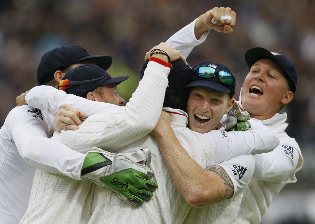 England's players hug Moeen Ali after he caught out New Zealand's Trent Boult to win the match. Photo / AP