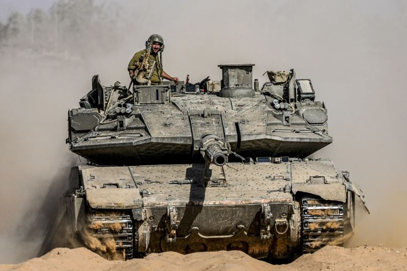 Israeli soldiers drive a tank at a staging ground near the border with the Gaza Strip, in southern Israel. Photo / AP