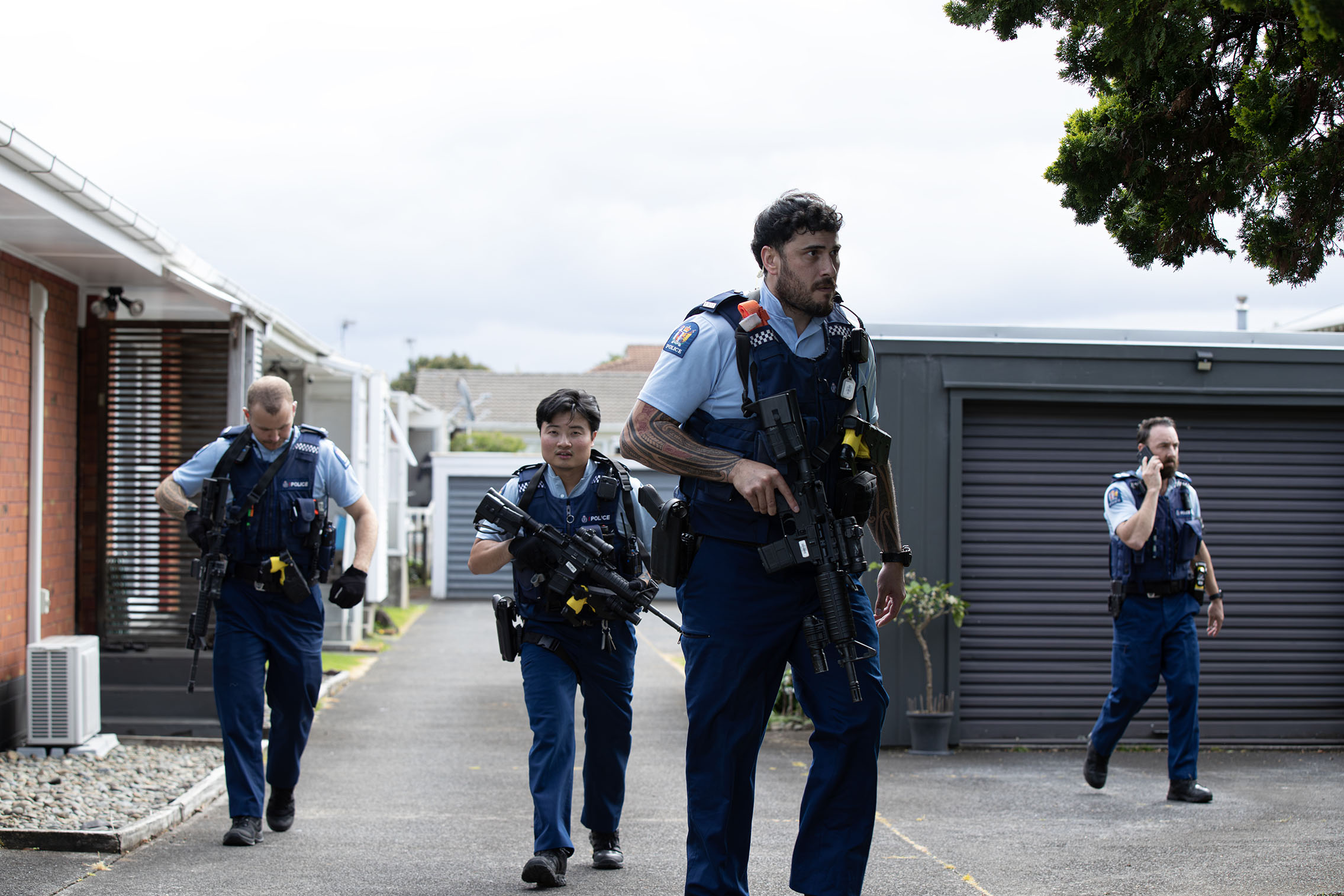Armed police search a property on Victoria St, Onehunga, after a stabbing on a bus nearby. Photo / Hayden Woodward
