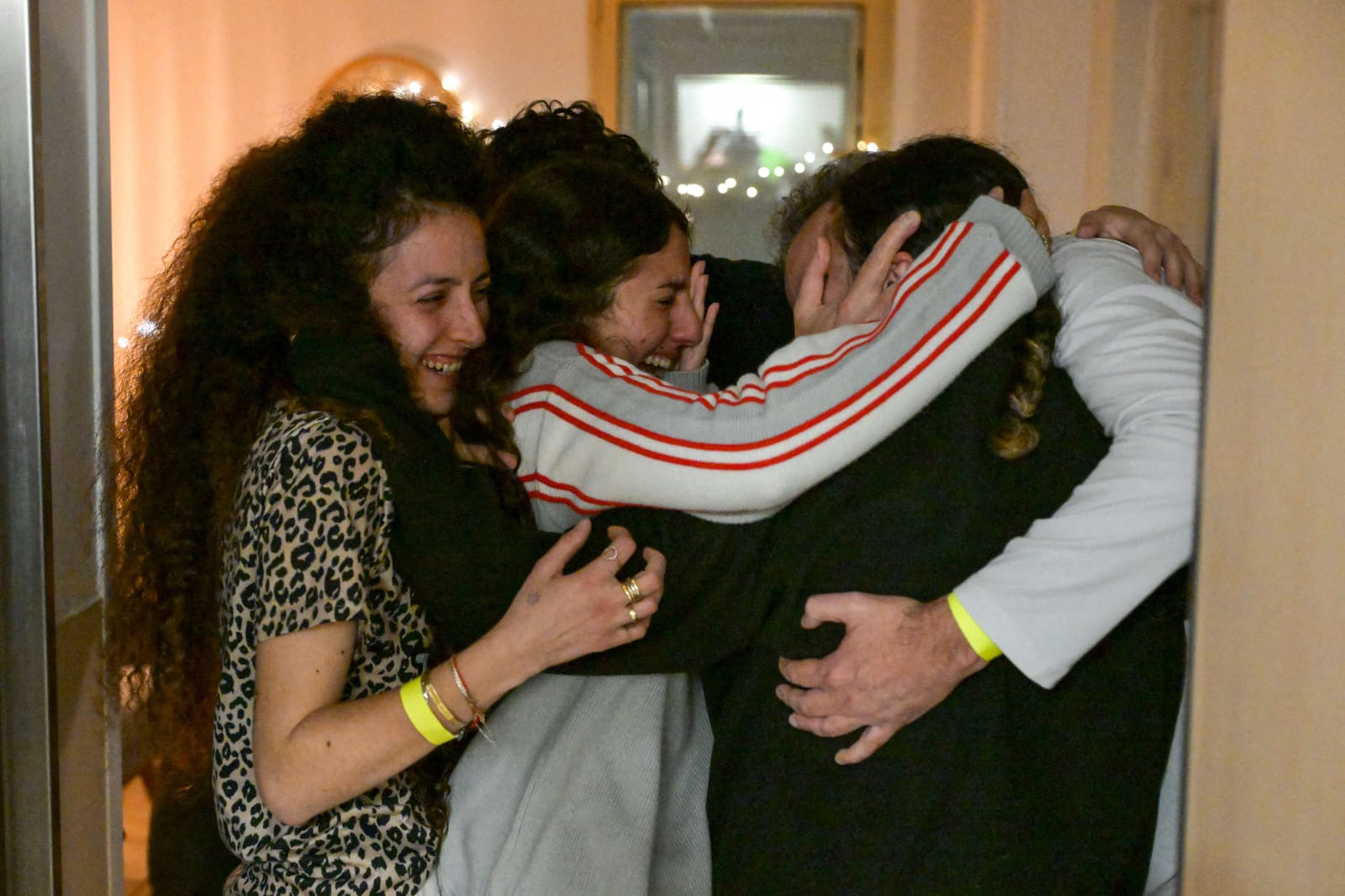 The father (right) of Israeli hostage Romi Gonen (second right) and other family members reunite after her release. Photo / AFP