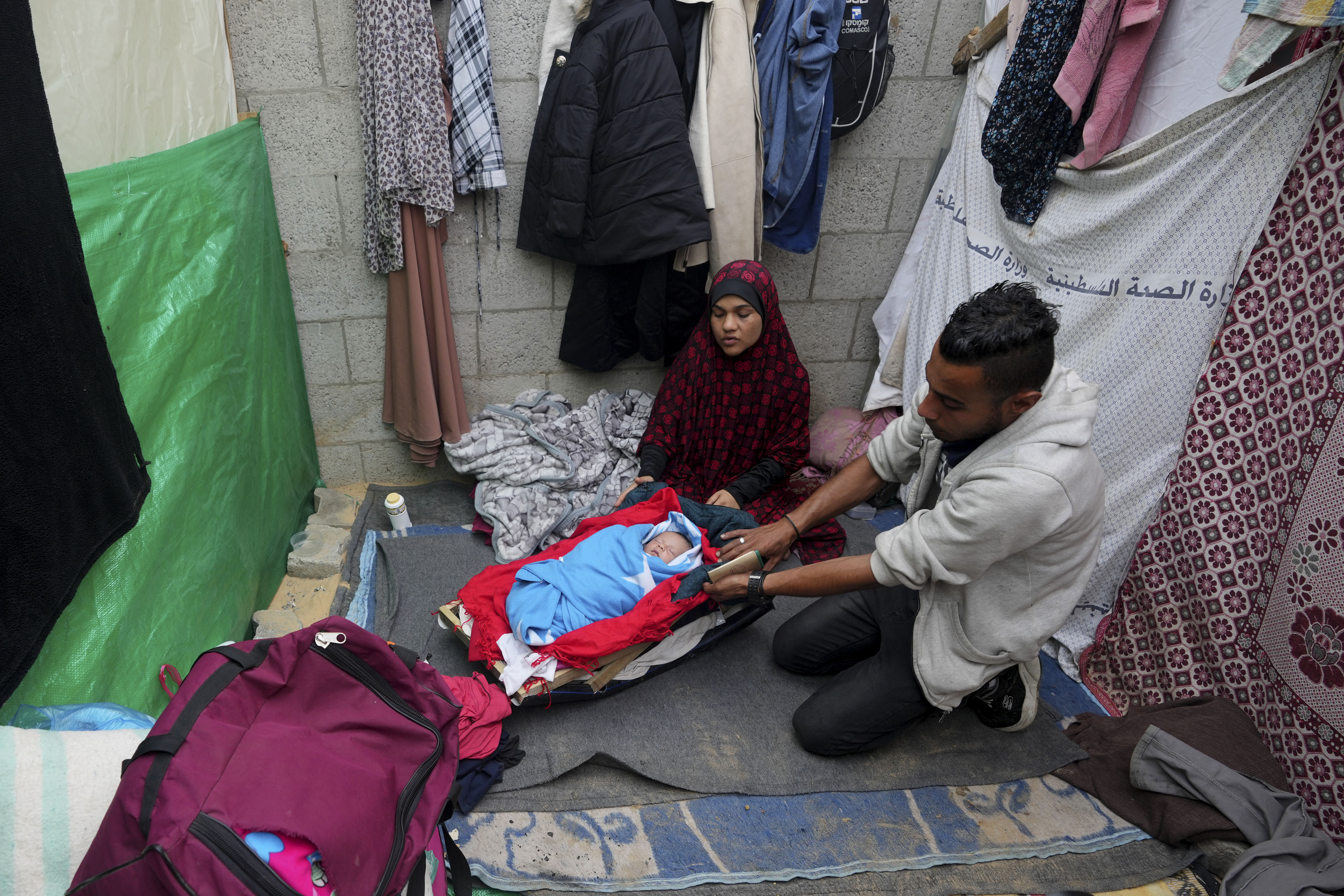 Displaced Palestinians sit with their newborn daughter at their makeshift tent near al Aqsa Hospital in Deir al Balah, Gaza Strip. Photo / AP