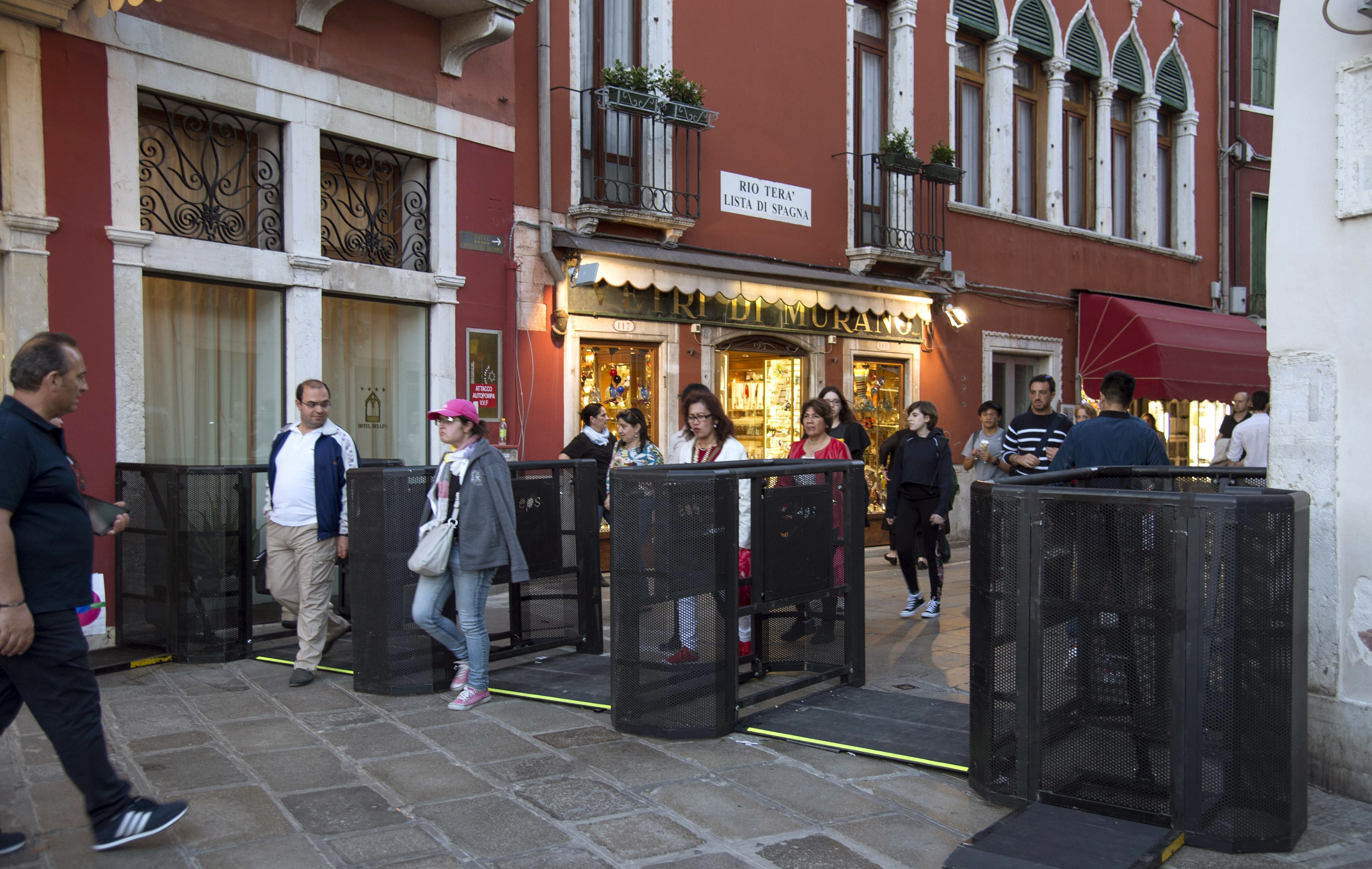 People walk through gates in Venice, Italy, which have been installed to turn back tourists if their numbers become too great. Photo / AP