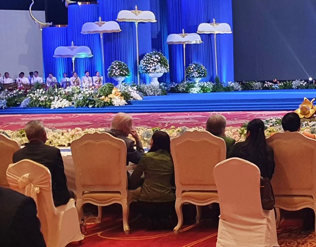 Prime Minister Jacinda Ardern crouches next to US President Joe Biden at the gala dinner ahead of the East Asia Summit in Cambodia. Photo / Supplied