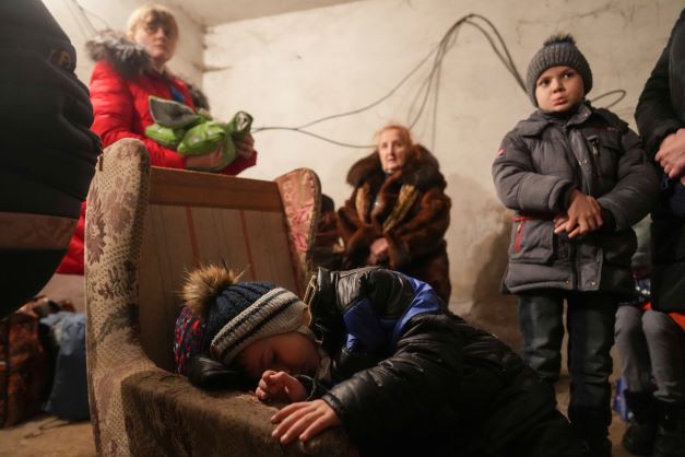 A child sleeps in an armchair as others stand around in a shelter during Russian shelling, in Mariupol, Ukraine. Photo / AP file 