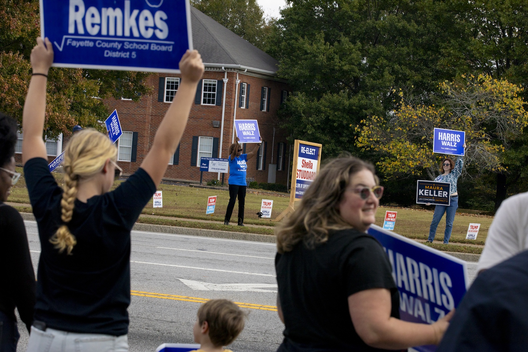 People wave Harris-Walz campaign signs to passersby in Fayetteville, Georgia. after a campaign that has seen the Democrats courting women voters. Photo / Kendrick Brinson for The Washington Post