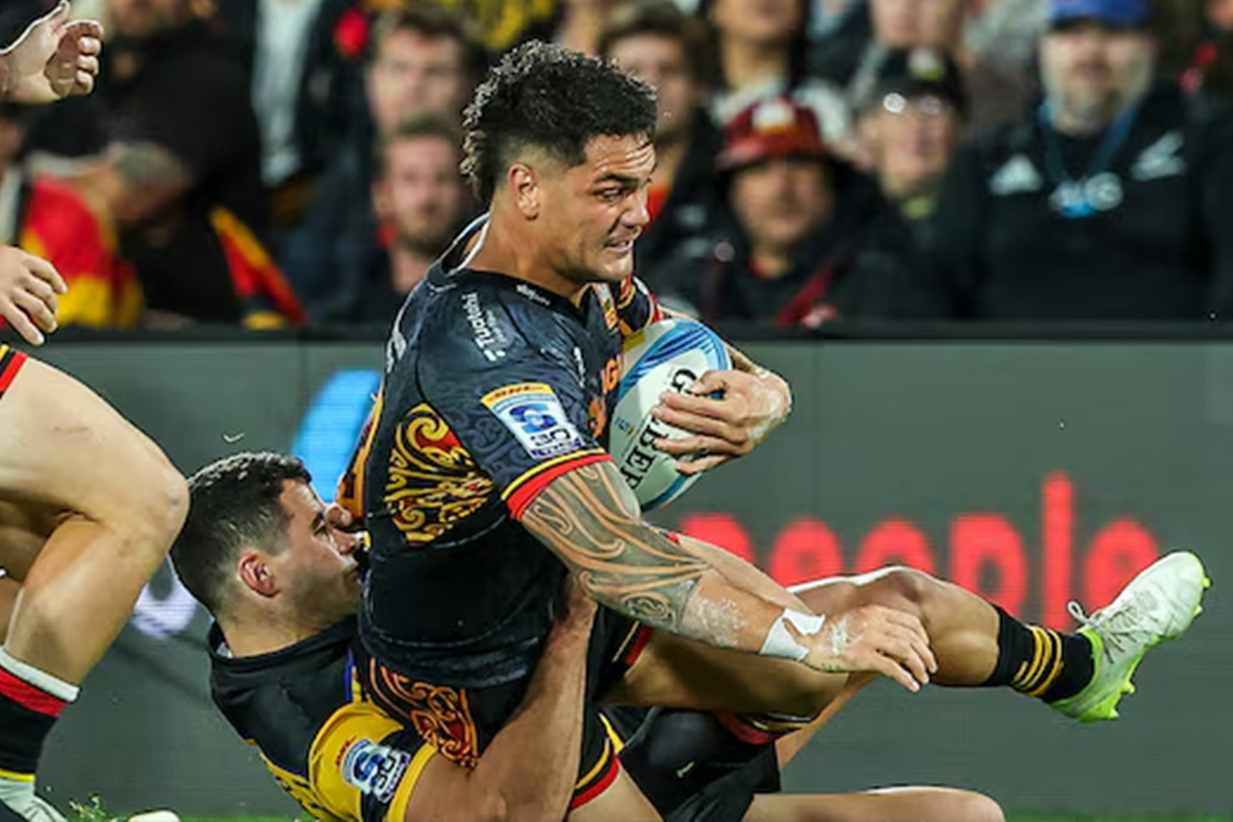 Chiefs midfielder Quinn Tupaea is brought down in last night's match against the Hurricanes. Photo / Photosport