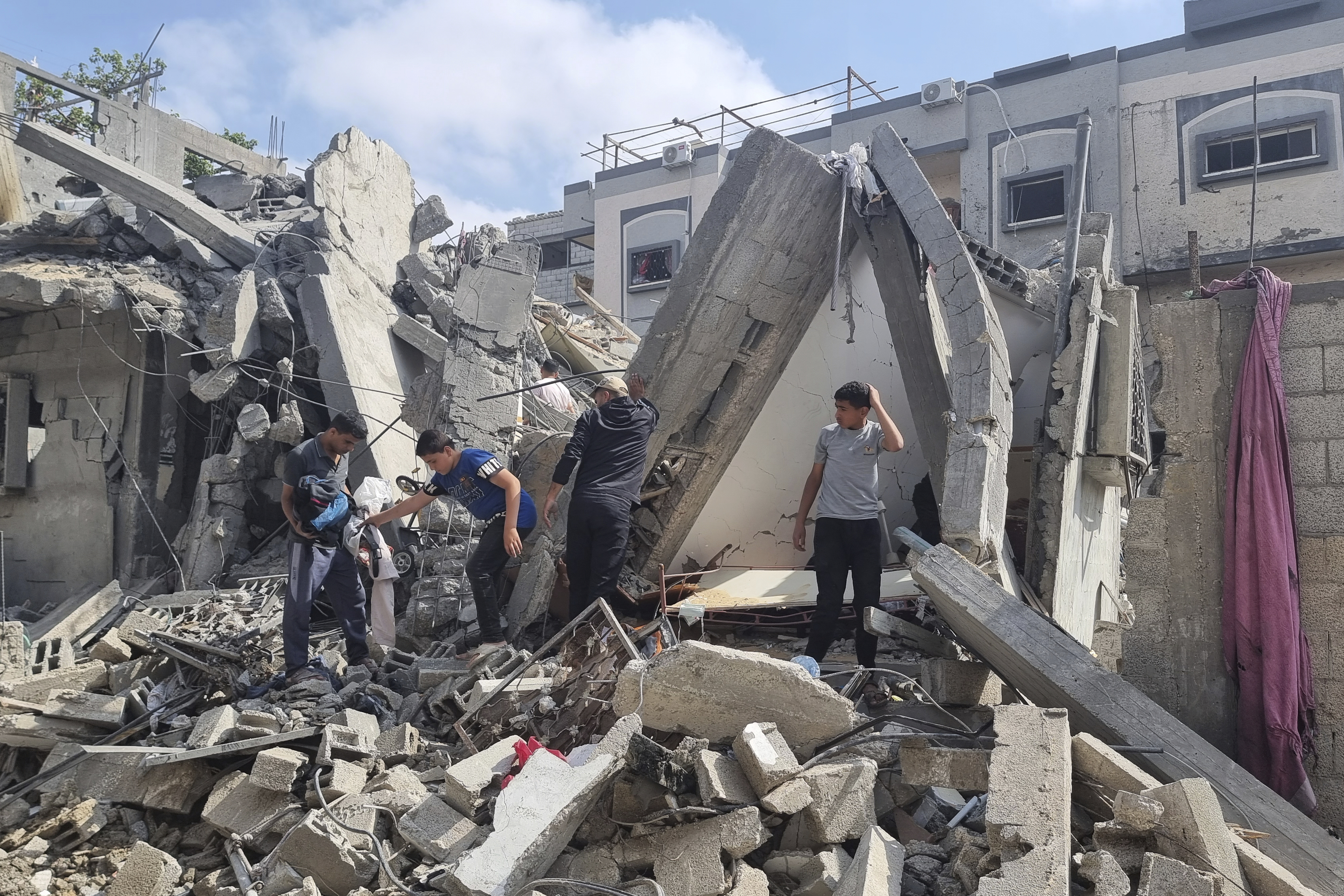 Palestinians look at the destruction after an Israeli airstrike in Rafah, Gaza Strip. Photo / AP