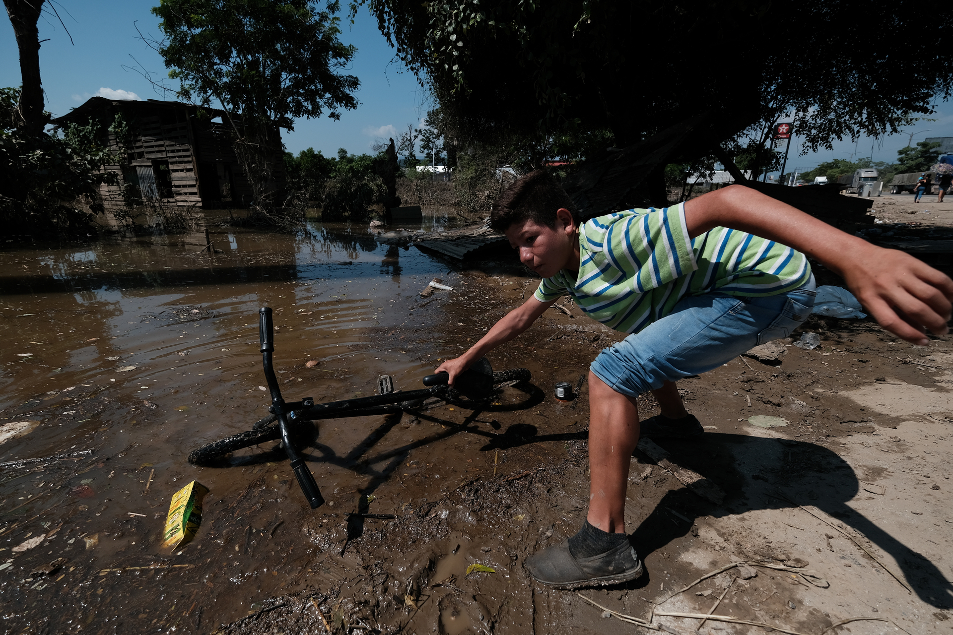 A kid of Colonia Planeta finds his lost bike in mud amid flooded streets after the flood produced by Tropical Storm Eta. Photo / Getty