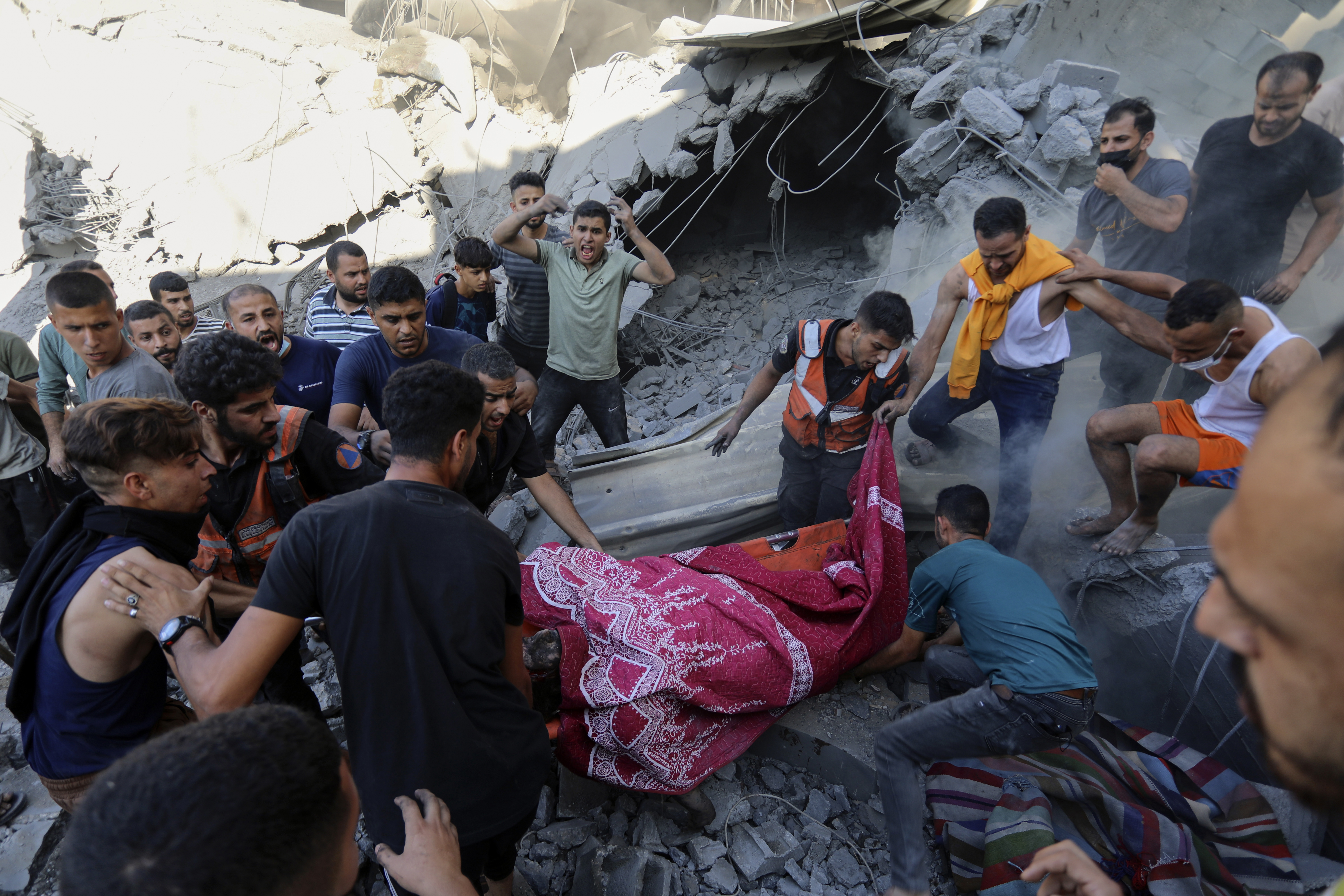 Palestinians carry a dead person from under the rubble of a destroyed house following an Israeli airstrike in Gaza City on Saturday, November 4, 2023. AP Photo / Abed Khaled