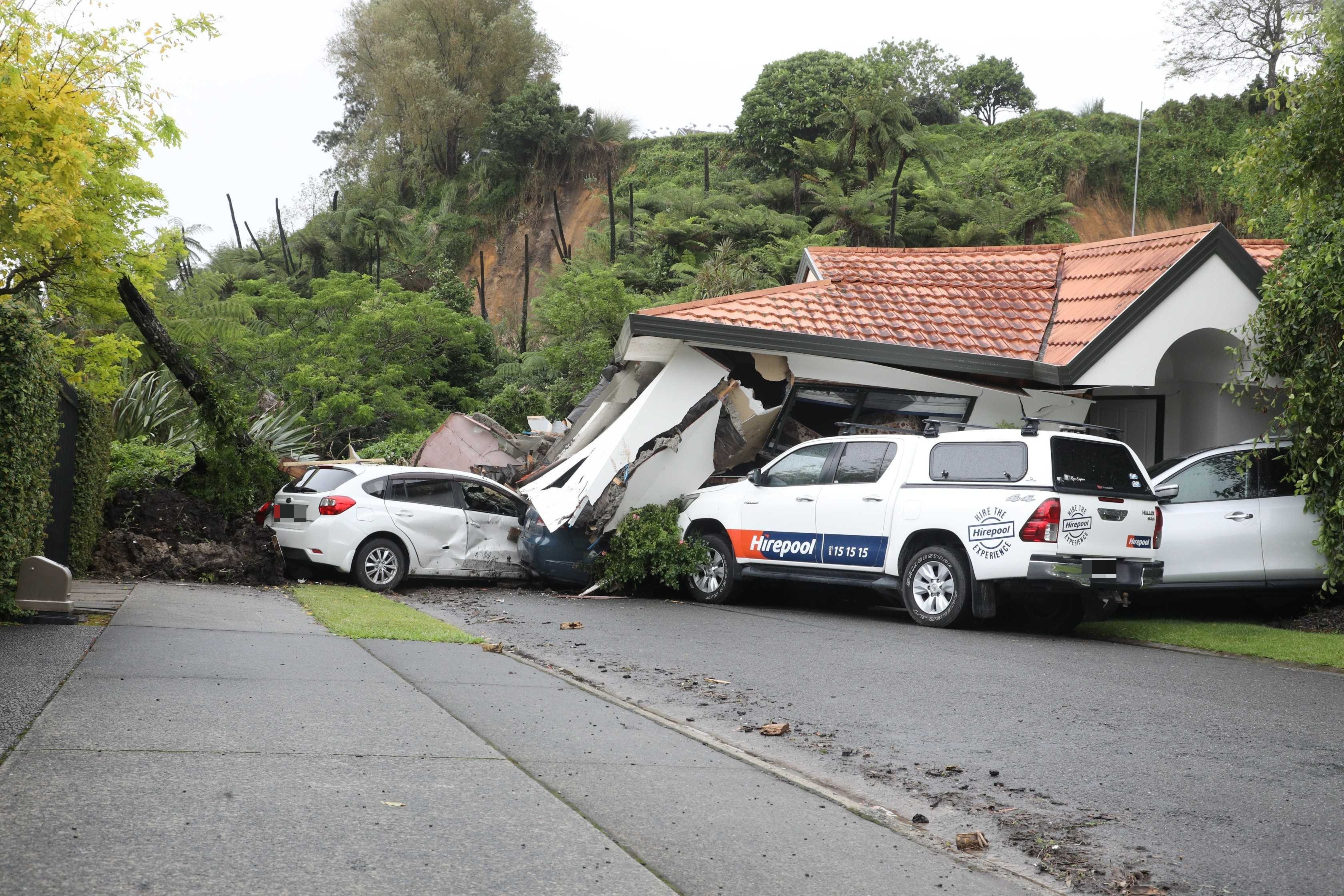 A landslide has fallen down on a house and cars in Maungatapu. Photo / Andrew Warner