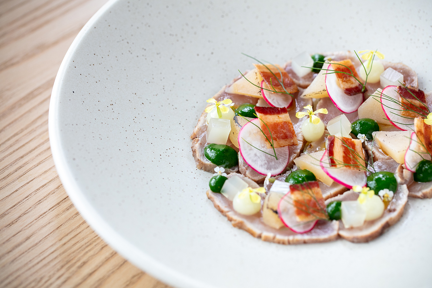 Kingfish crudo with pancetta and roast apple. Photo / Babiche Martens
