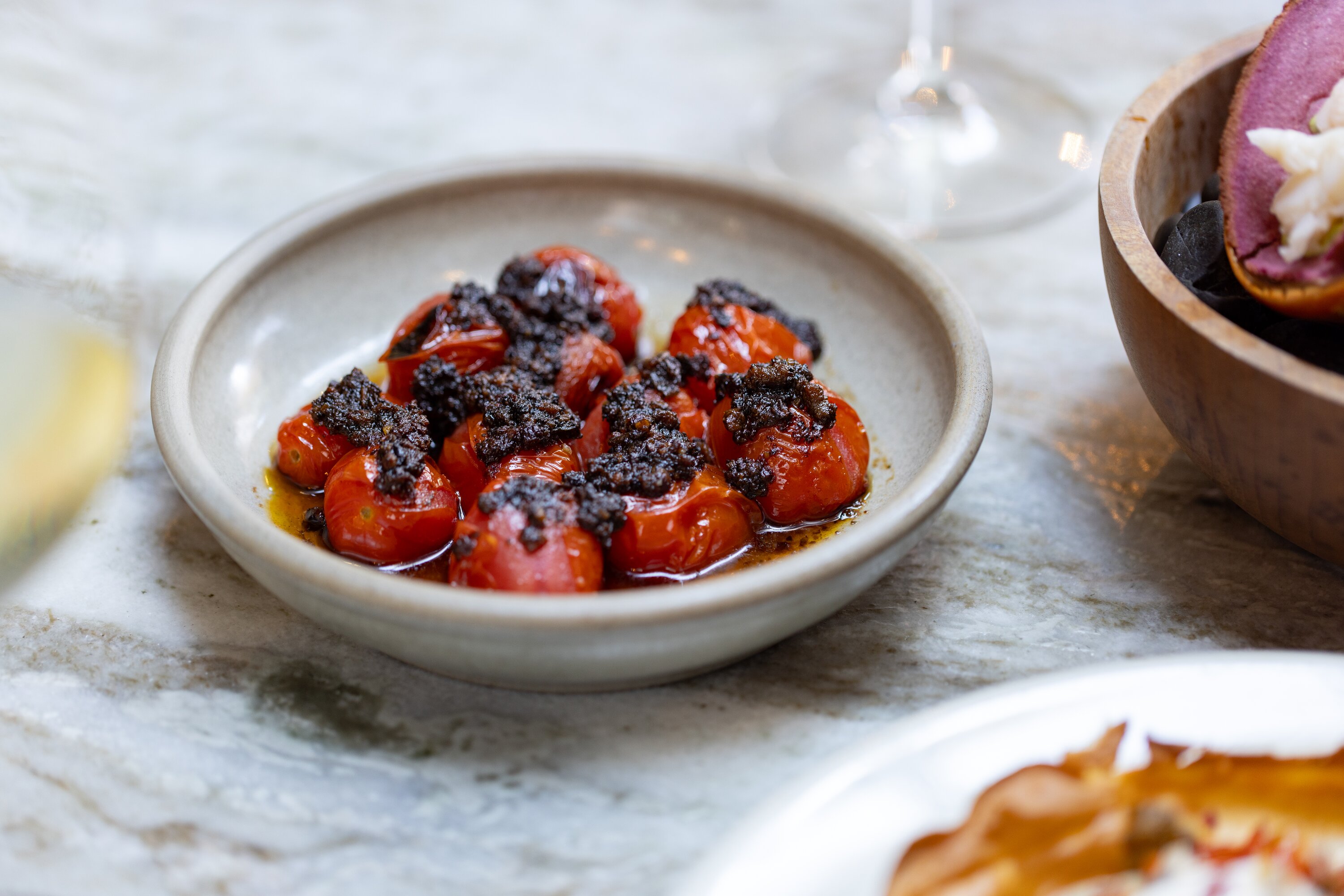 Roast cherry heirloom tomatoes with a paua XO sauce. Photo / Babiche Martens