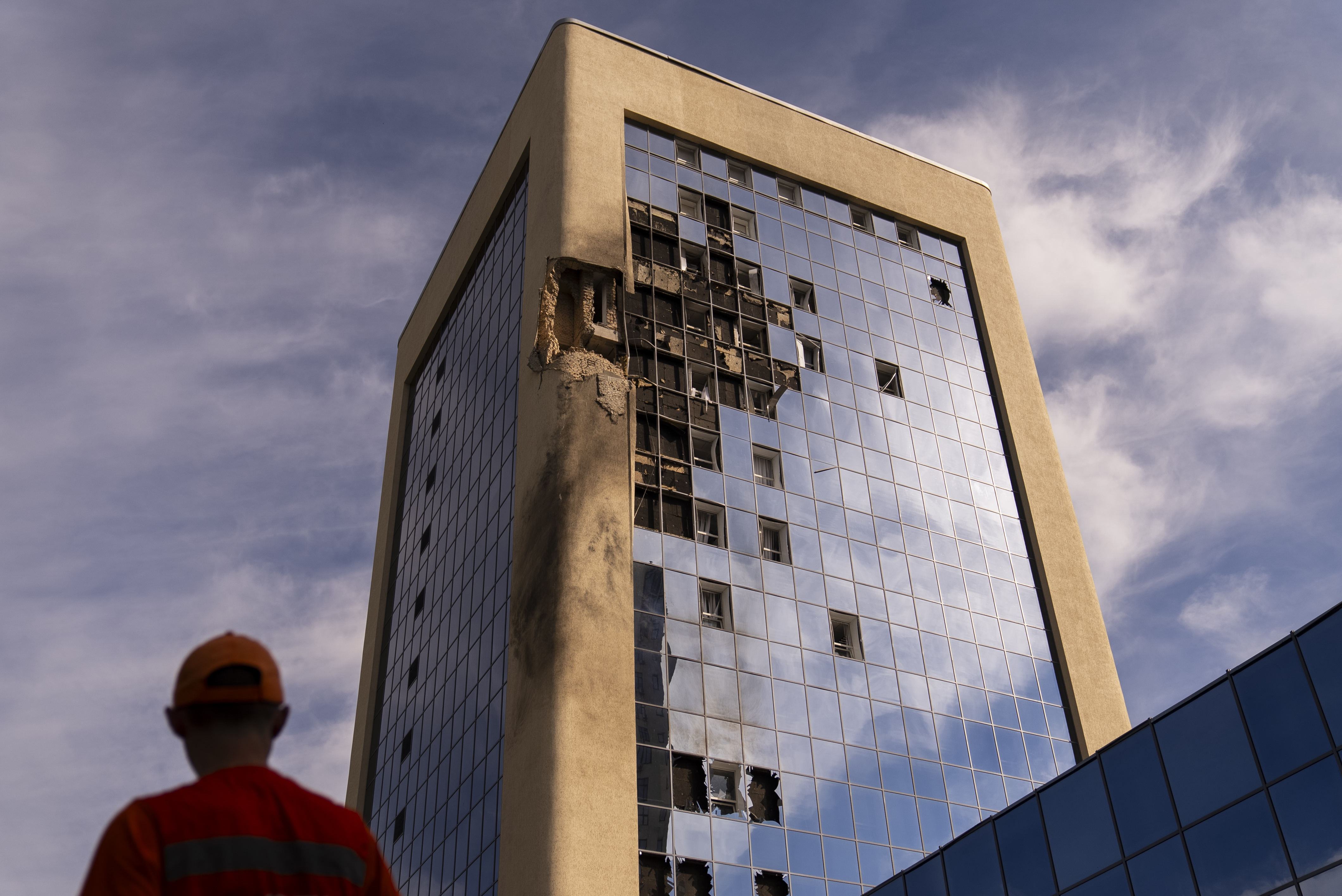 A maintenance worker stands outside a damaged government building in Kyiv, Ukraine. Photo / AP