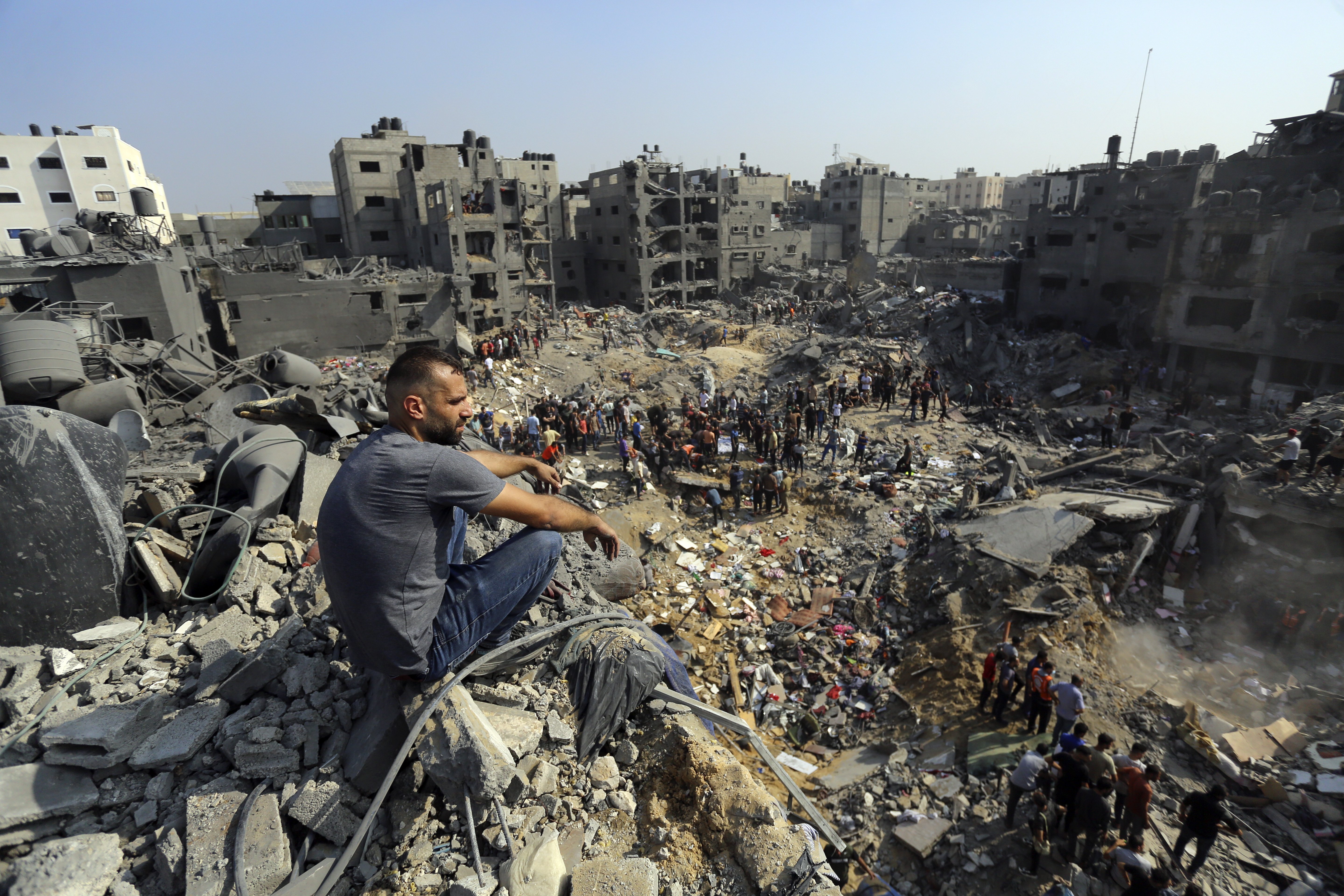 A man sits on the rubble overlooking the debris of buildings that were targeted by Israeli airstrikes in the Jabaliya refugee camp, northern Gaza Strip. Photo / AP