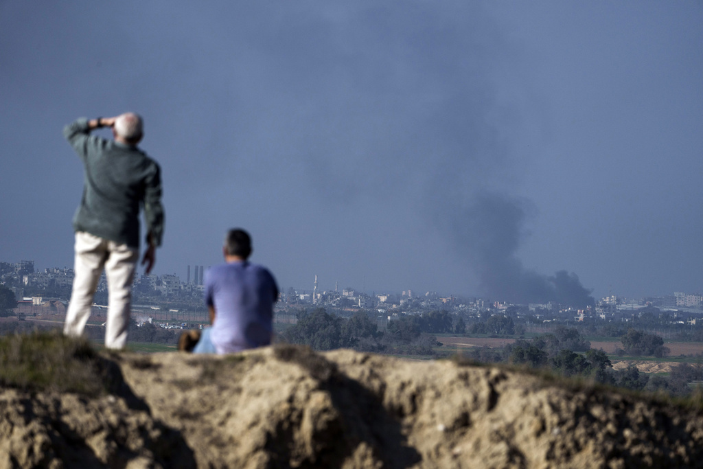 People watch smoke rising after an explosion in the Gaza Strip, as seen from southern Israel on January 6. In Gaza, Israel is moving to scale down its military assault in the north of the territory and pressing its heavy offensive in the south, vowing to crush Hamas. Photo / AP