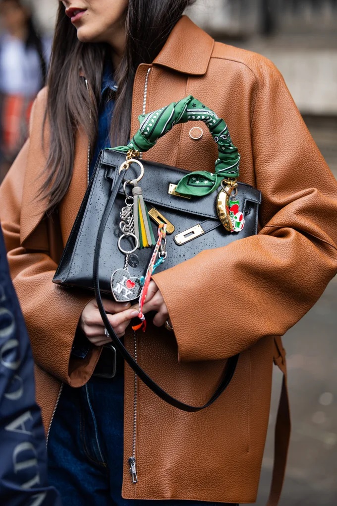 Oversized key-charms and scarves can help personalise a bag. Photo / Getty Images
