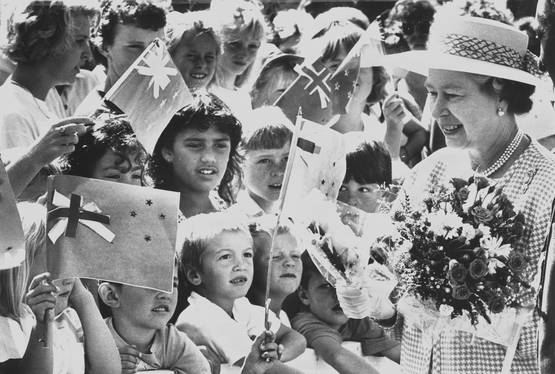 Queen Elizabeth meets young children, some with makeshift New Zealand flags, during a visit to Queenstown in 1990. Photo / New Zealand Herald
