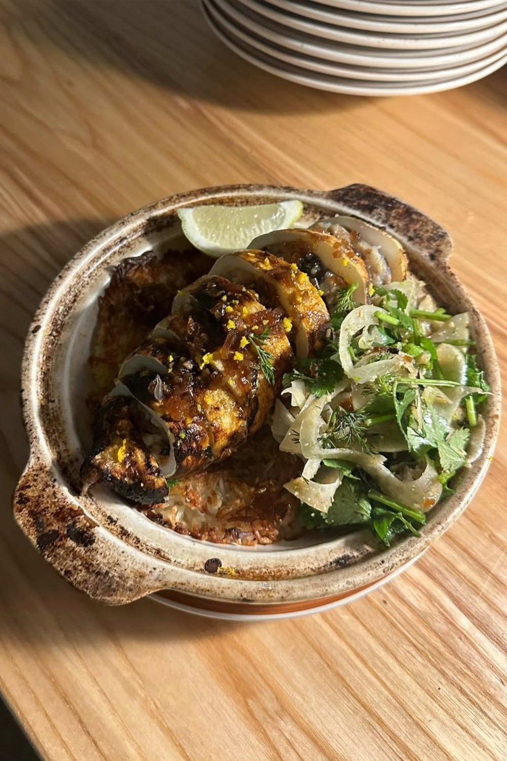 The pizza oven does double duty, also used for a range of claypot dishes, like this Hội An style baked squid rice. Photo / @lillies.lillies.lillies