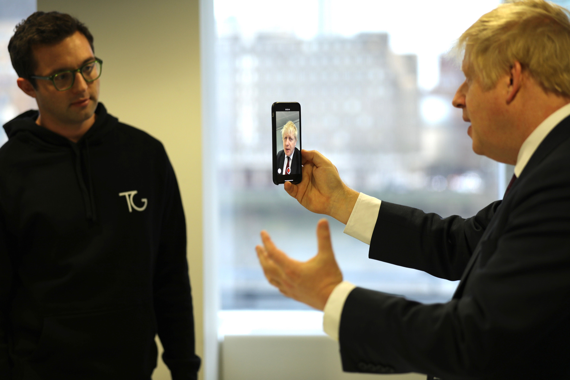 Topham watches as former UK Prime Minister Boris Johnson takes a selfie during the Conservatives' 2019 general election campaign.