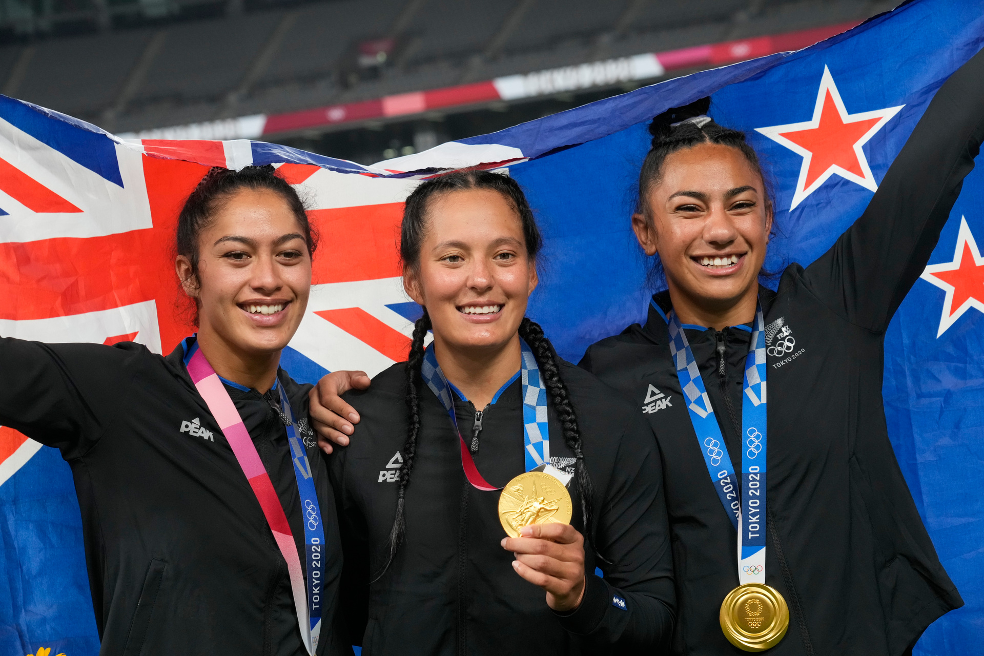 New Zealand's Shiray Kaka, left, Tyla Nathan-Wong and Risi Pouri-Lane, pose with their gold medals after winning the women's sevens final at he Tokyo Olympics. Photo / AP