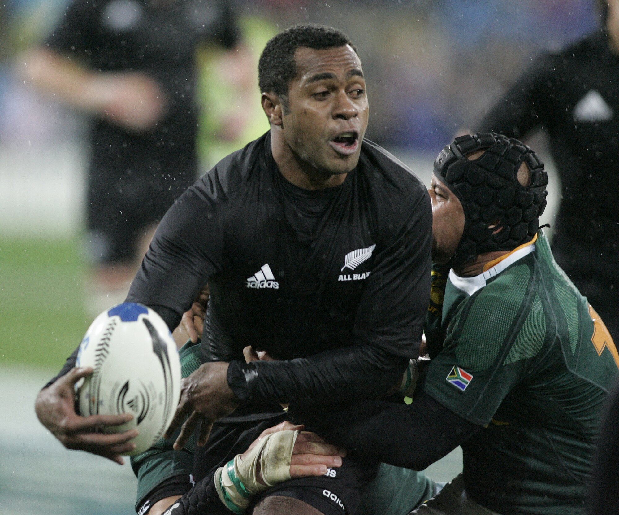 All Blacks wing Sitiveni Sivivatu gets a pass away in the tackle of Springboks centre Adrian Jacobs in Wellington. Photo / Mark Mitchell