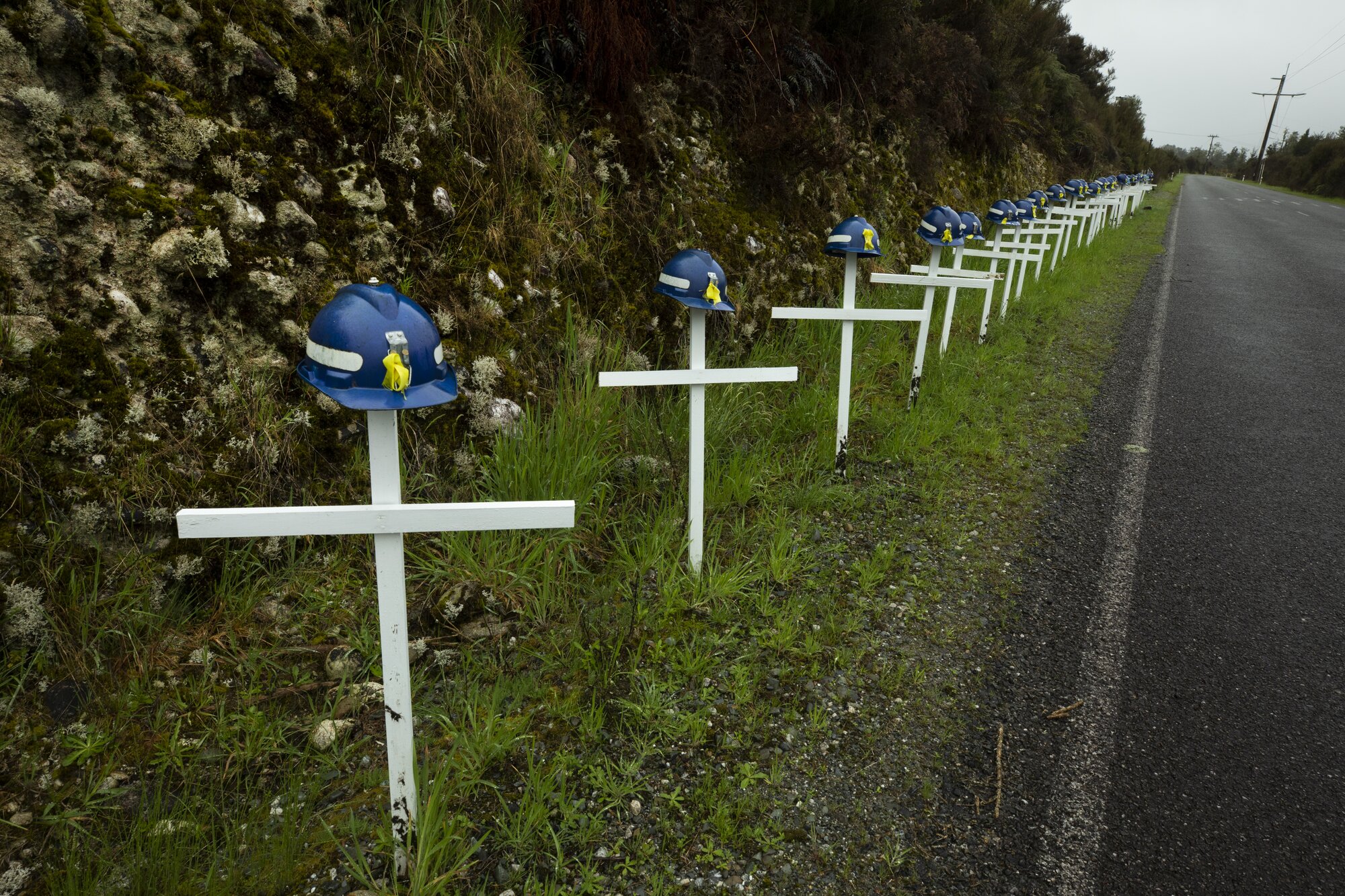 Twenty-nine crosses with mine helmets stand on the side of the road that leads to the Pike River Mine portal, in tribute to those who died in the disaster. Photo / Brett Phibbs