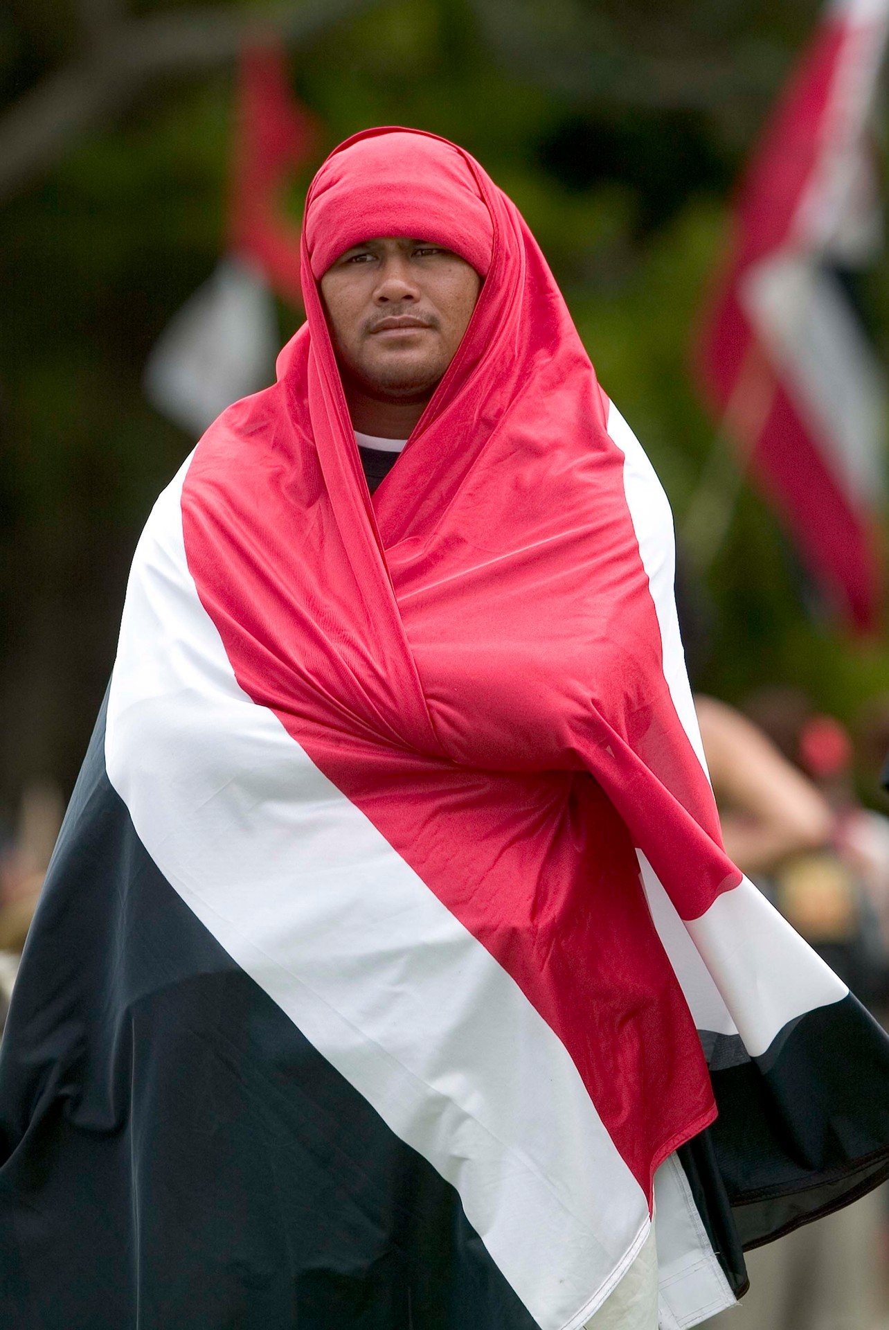 A man drapes himself in the tino rangatiratanga flag on the Treaty grounds in 2006. Photo / Richie Robinson