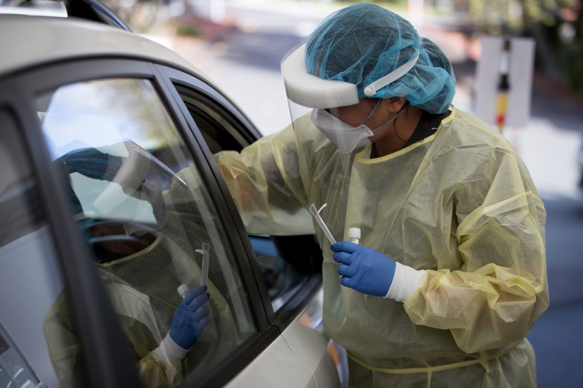 A Covid-19 worker administers a test at a drive-through testing centre in Northcote in 2022. Photo / Dean Purcell