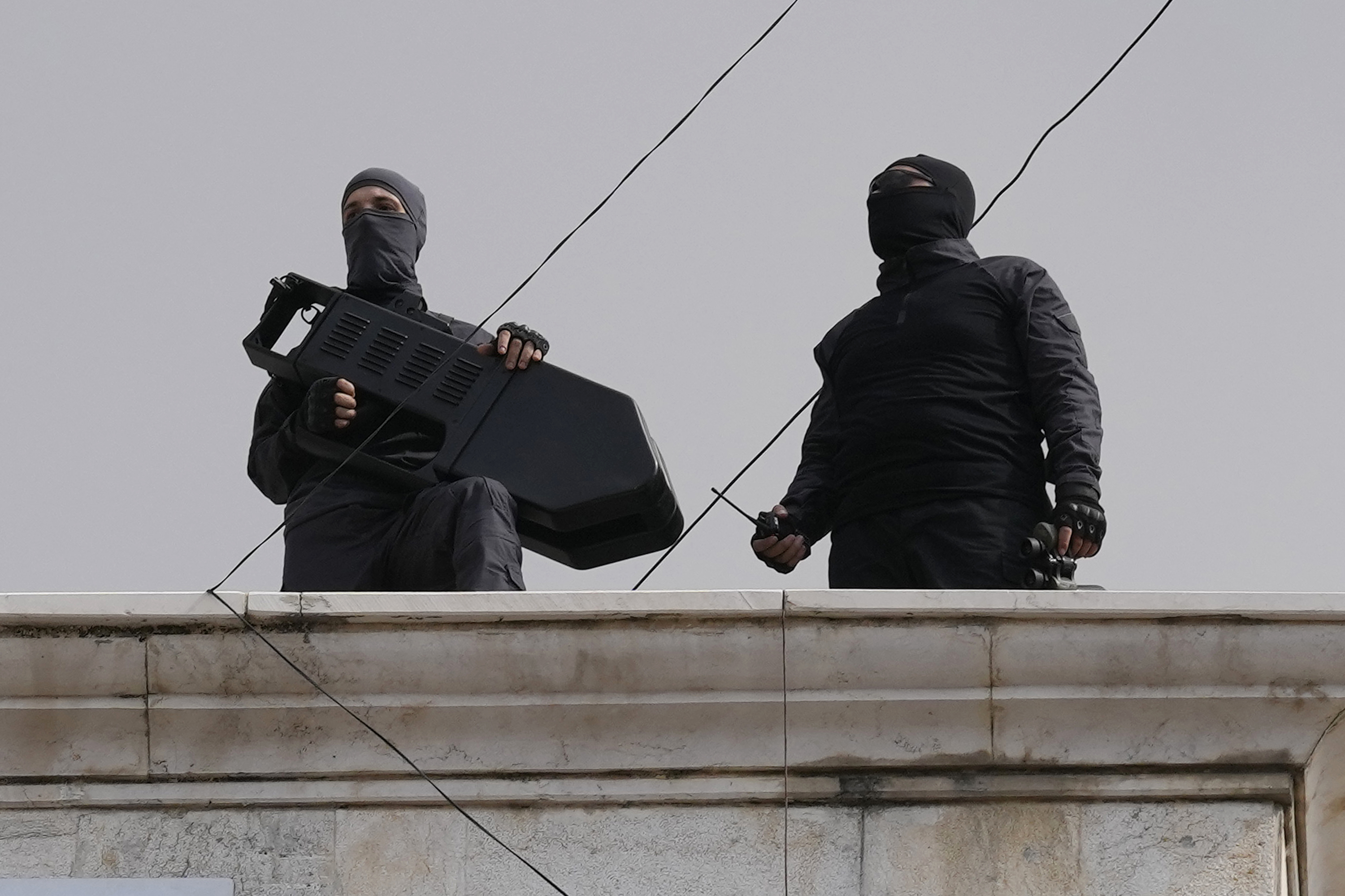 Hezbollah fighters stand guard on a building rooftop to protect their supporters during a protest to show their solidarity with the Palestinians. Photo / AP