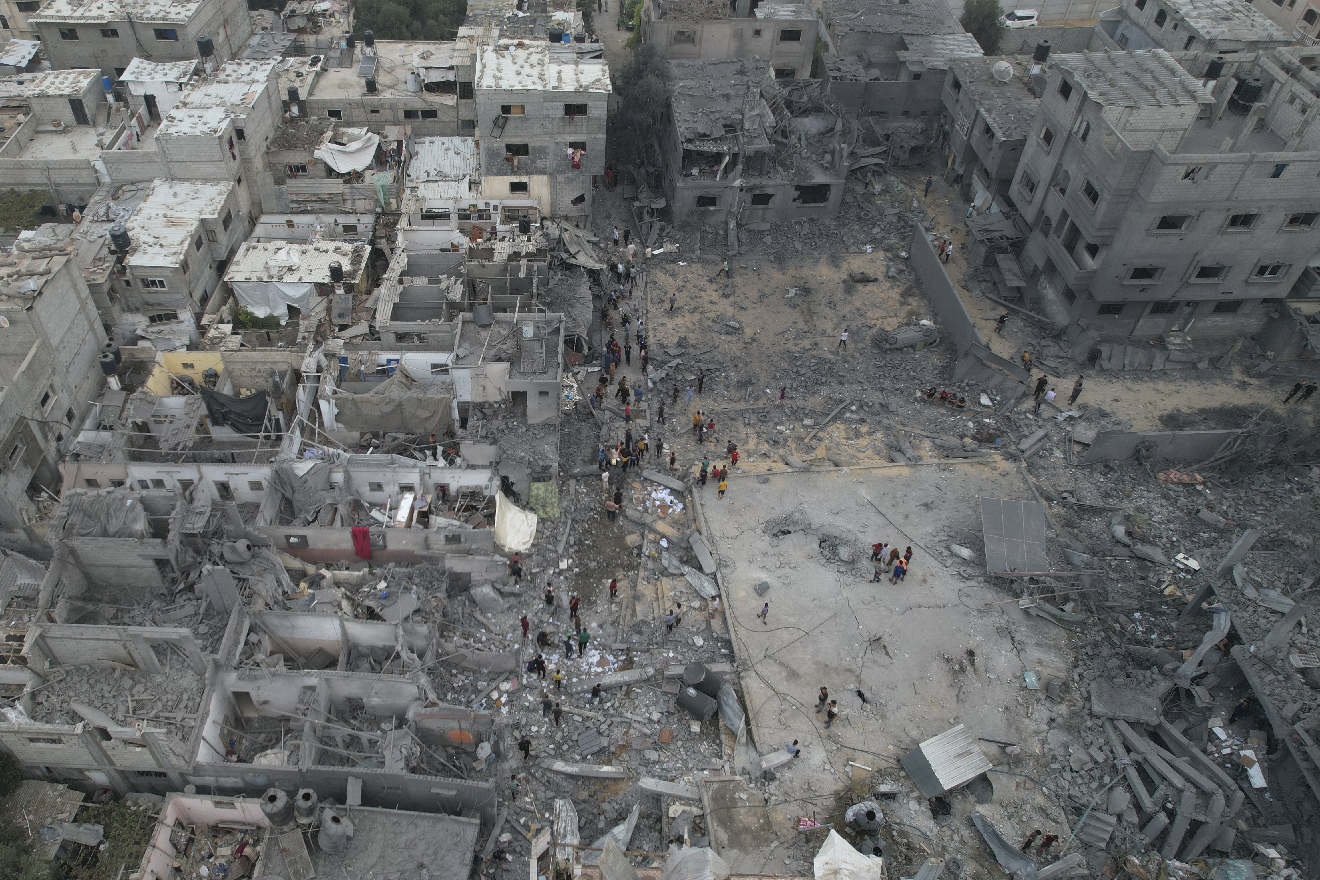 Palestinians walk among buildings destroyed in the Israeli bombardment in the Nusseirat refugee camp in the Gaza Strip. Photo / AP