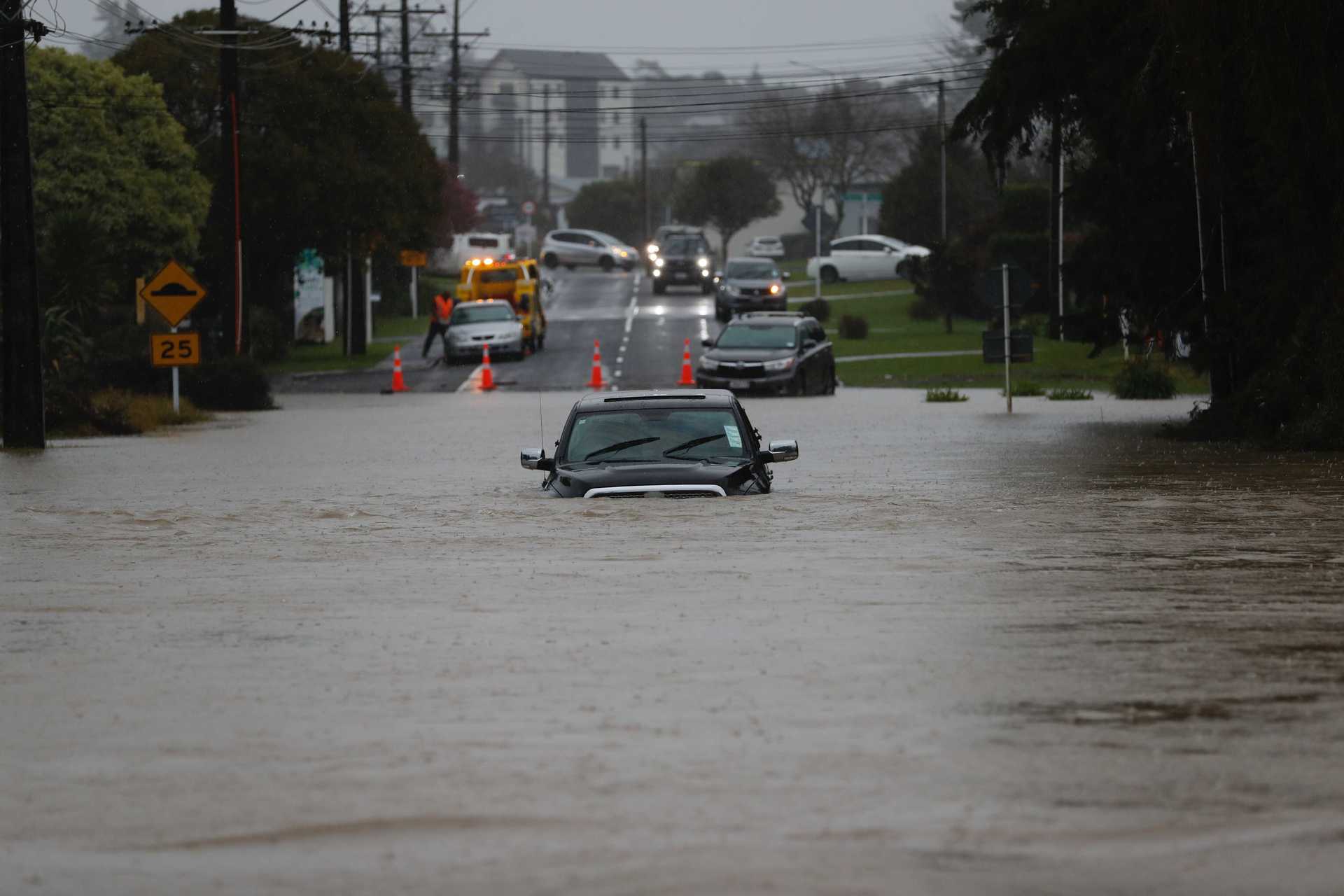 Cars have been trapped underwater as flood waters wreak havoc in west Auckland. Photo / Dean Purcell
