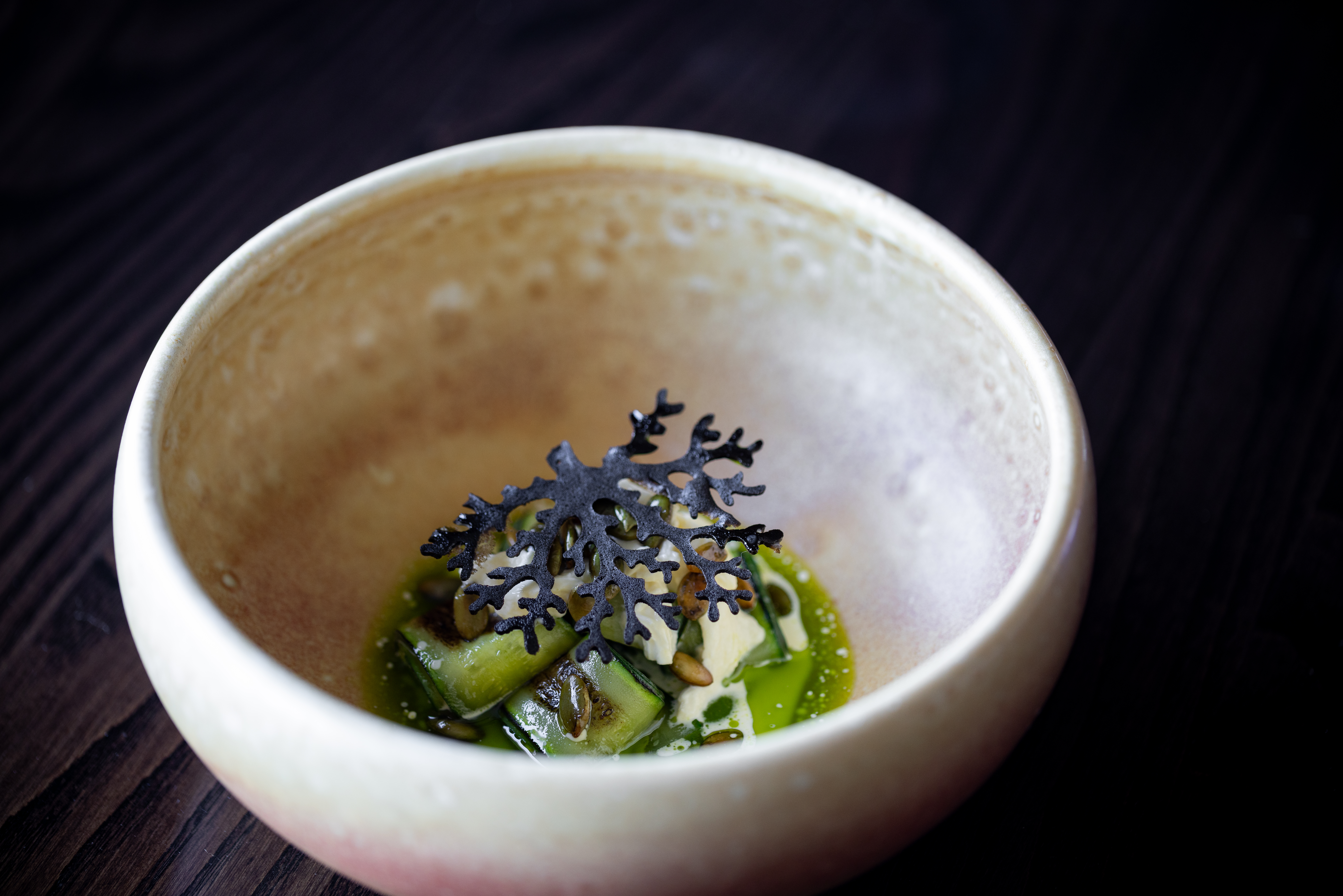 Charred courgettes, stracciatella, burnt onion ash, green chili puree. Photo / Babiche Martens