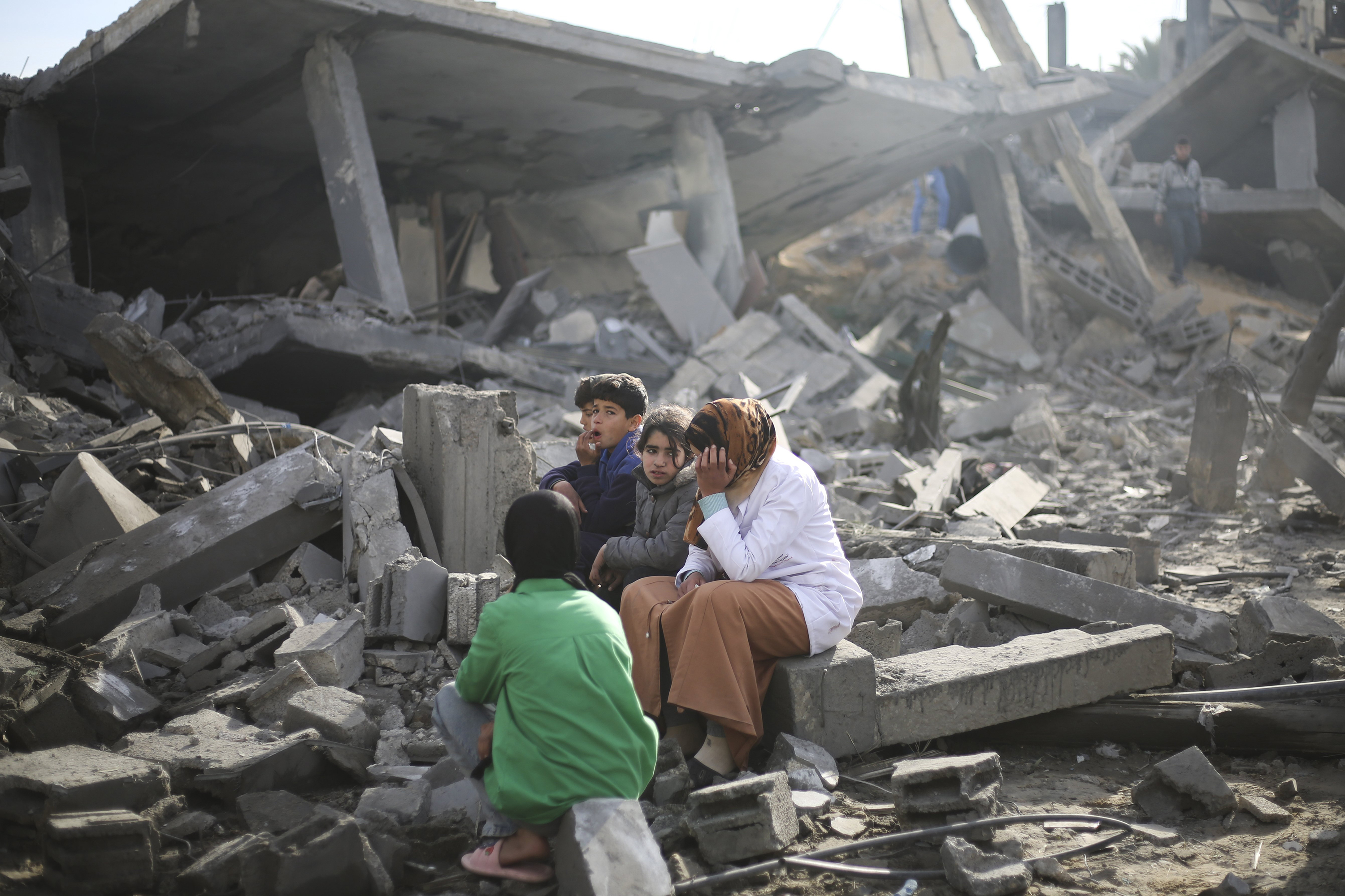 Palestinians sit by the destruction from the Israeli bombardment of the Gaza Strip in Rafah. Photo / AP
